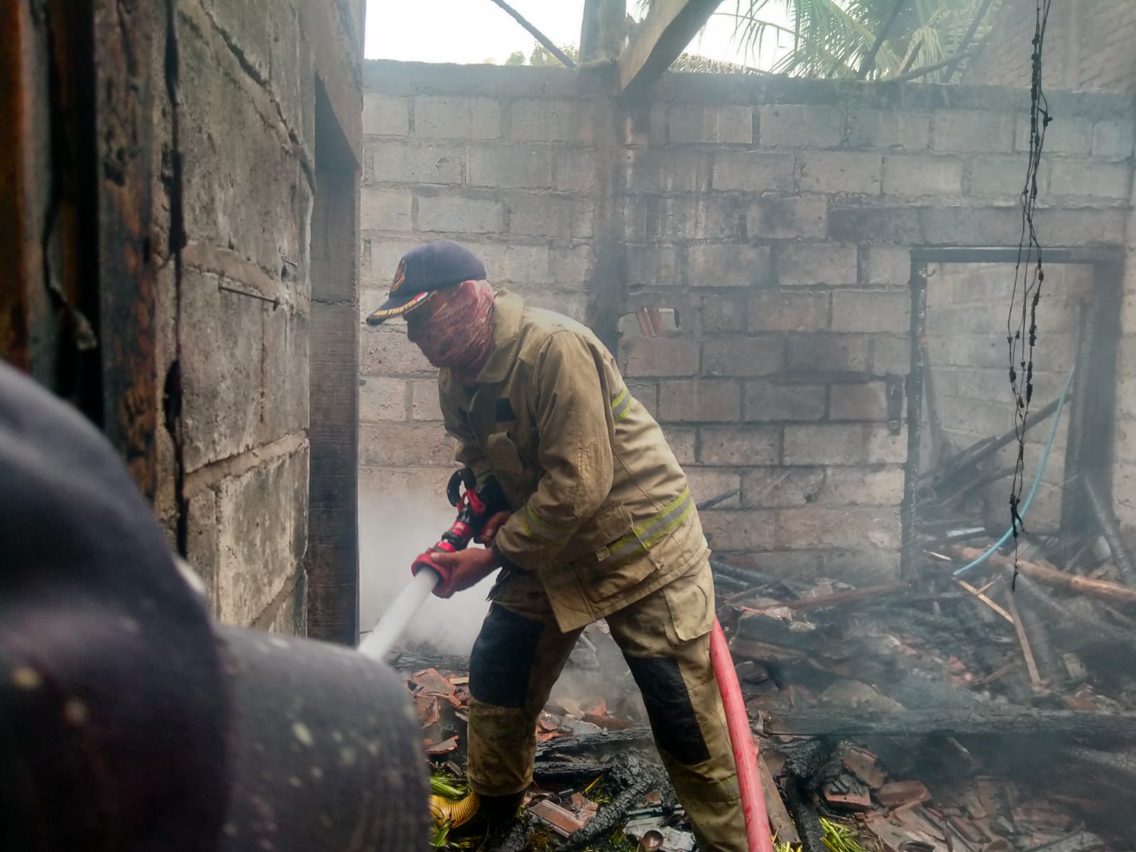 PEMADAMAN : Anggota Damkarla Pos Menganti, Kabupaten Gresik saat melaukan pemadaman api yang membakar rumah Karji di Desa Brangkal, Kecamatan Balongpanggang Kabupaten Gresik, Jumat (22/1).