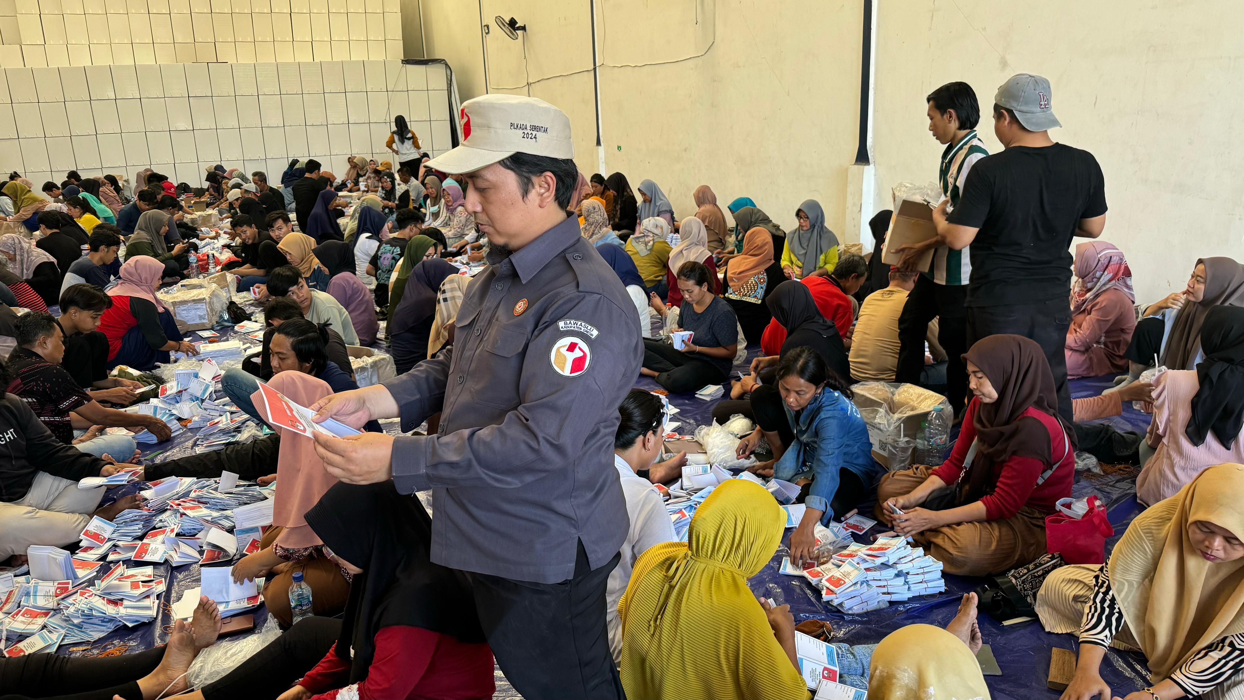 PENGAWASAN: Koordinator Divisi SDM, Organisasi dan Diklat Bawaslu Gresik Robbah Khunaifih saat melakukan pengawasan sortir dan lipat surat suara di gudang KPU.