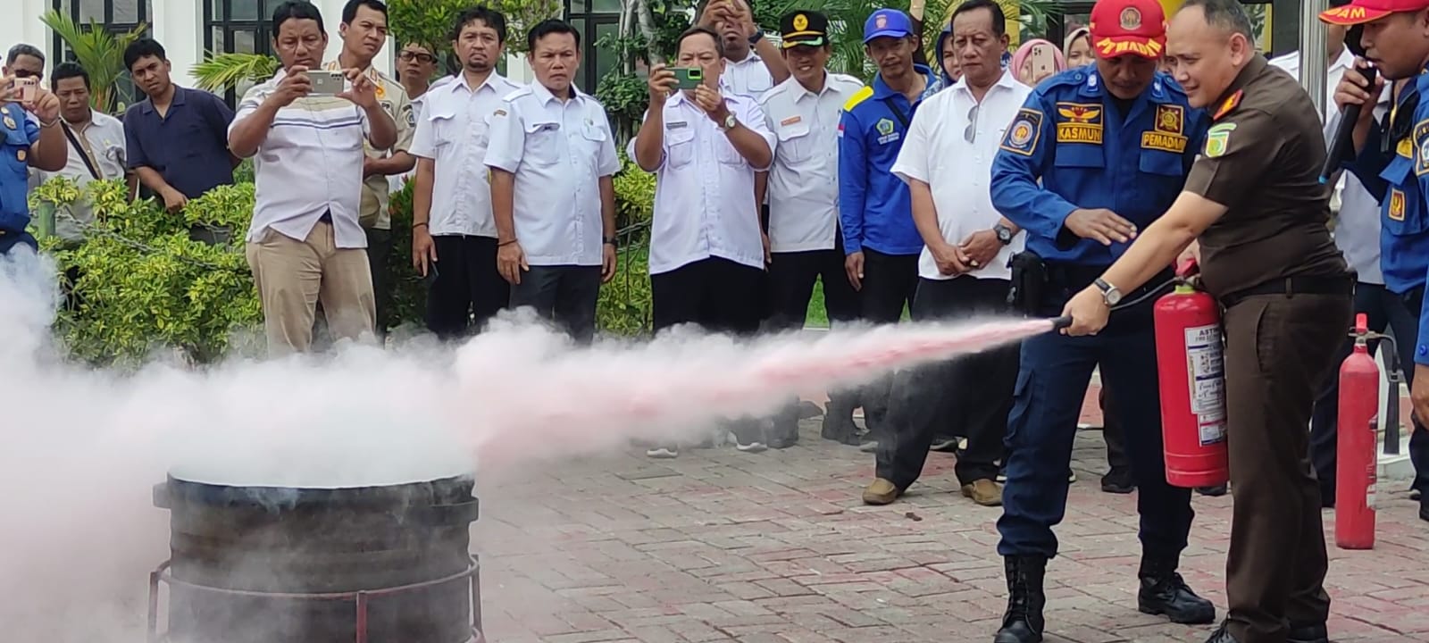 SIMULASI KEBAKARAN : Kajari Gresik Nana Riana saat melakukan simulasi kebakaran menggandeng Damkarla Gresik di kantor Kejari Gresik.