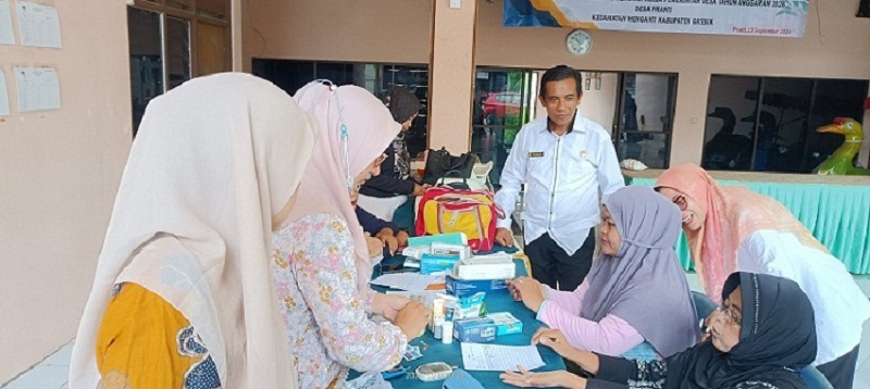 Peduli Kesehatan : Kepala Desa Pranti, Hardi saat mendampingi kader posyandu melaksanakan pemeriksaan kepada balita dan lansia di Balai desa.