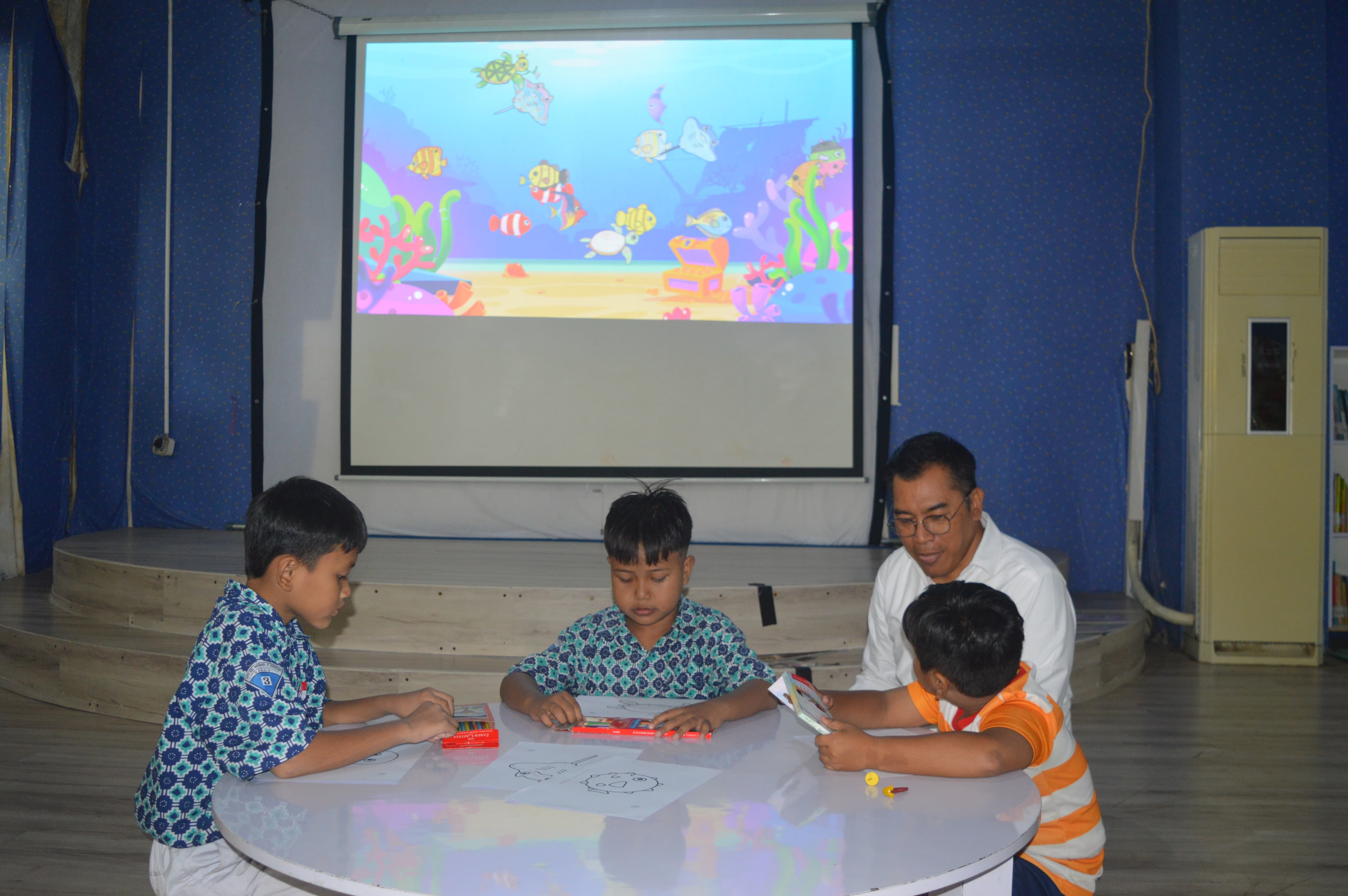 Kepala Dinas Perpussip Gresik Budi Raharjo saat mendampingi anak-anak belajar menggambar di fasilitas Aquarium Digital.