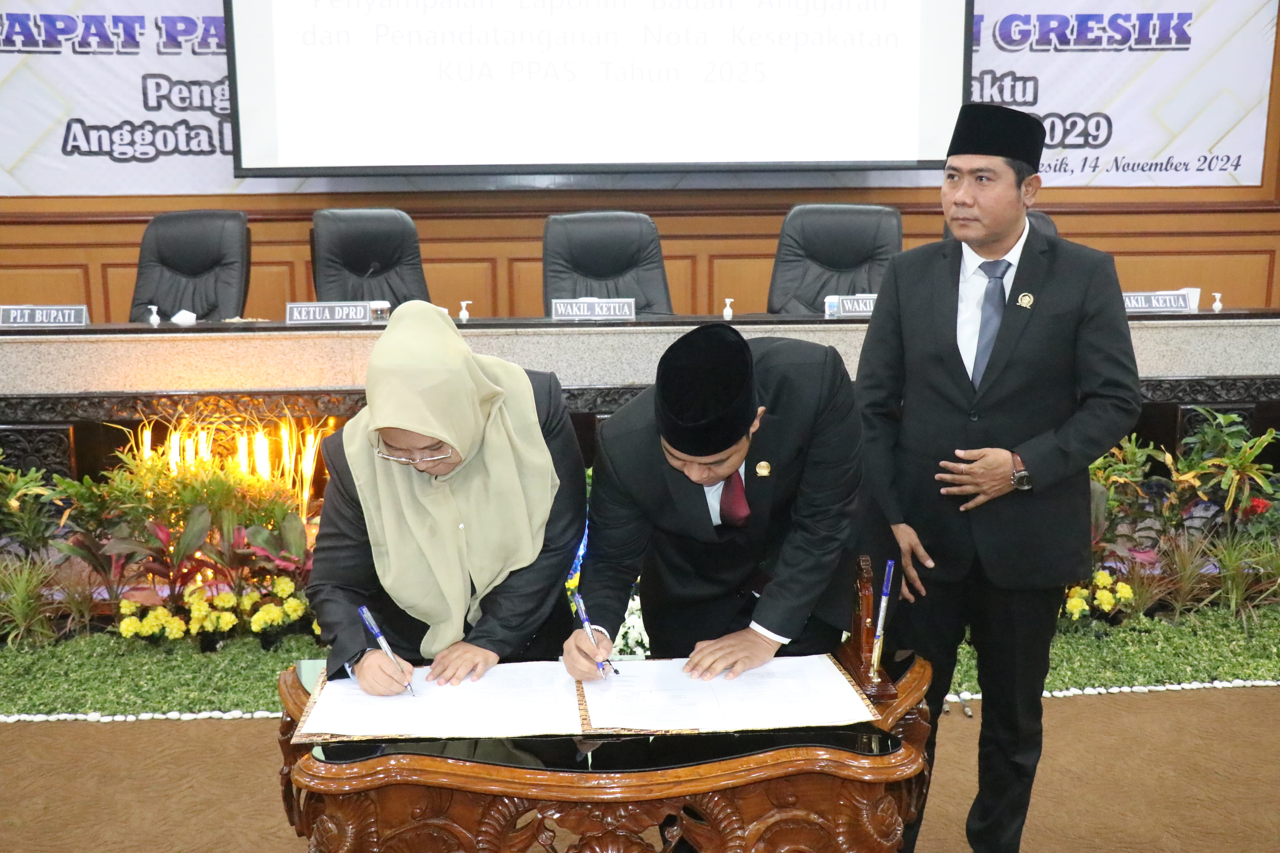 SEPAKAT: Plt Bupati Gresik Aminatun Habibah (kiri) dan Ketua DPRD Gresik M Syahrul Munir didampingi Wakil Ketua Lutfi Dhawam menandatangani nota kesepakatan KUA-PPAS 2025.