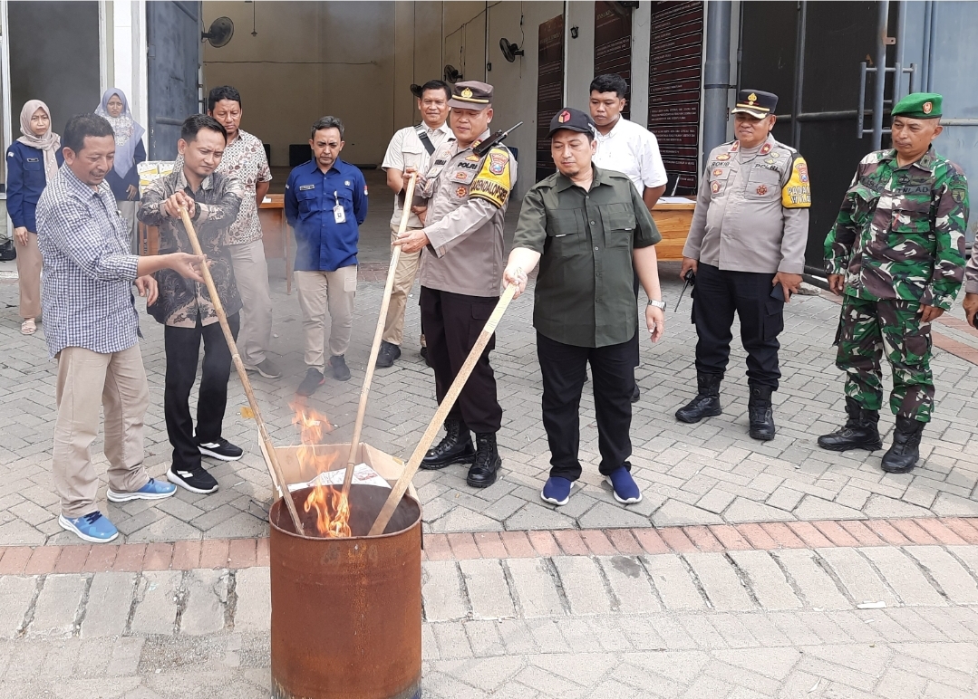 DIBAKAR: KPU bersama Bawaslu Gresik dan APH melakukan pembakaran surat suara rusak di depan gudan logistik.