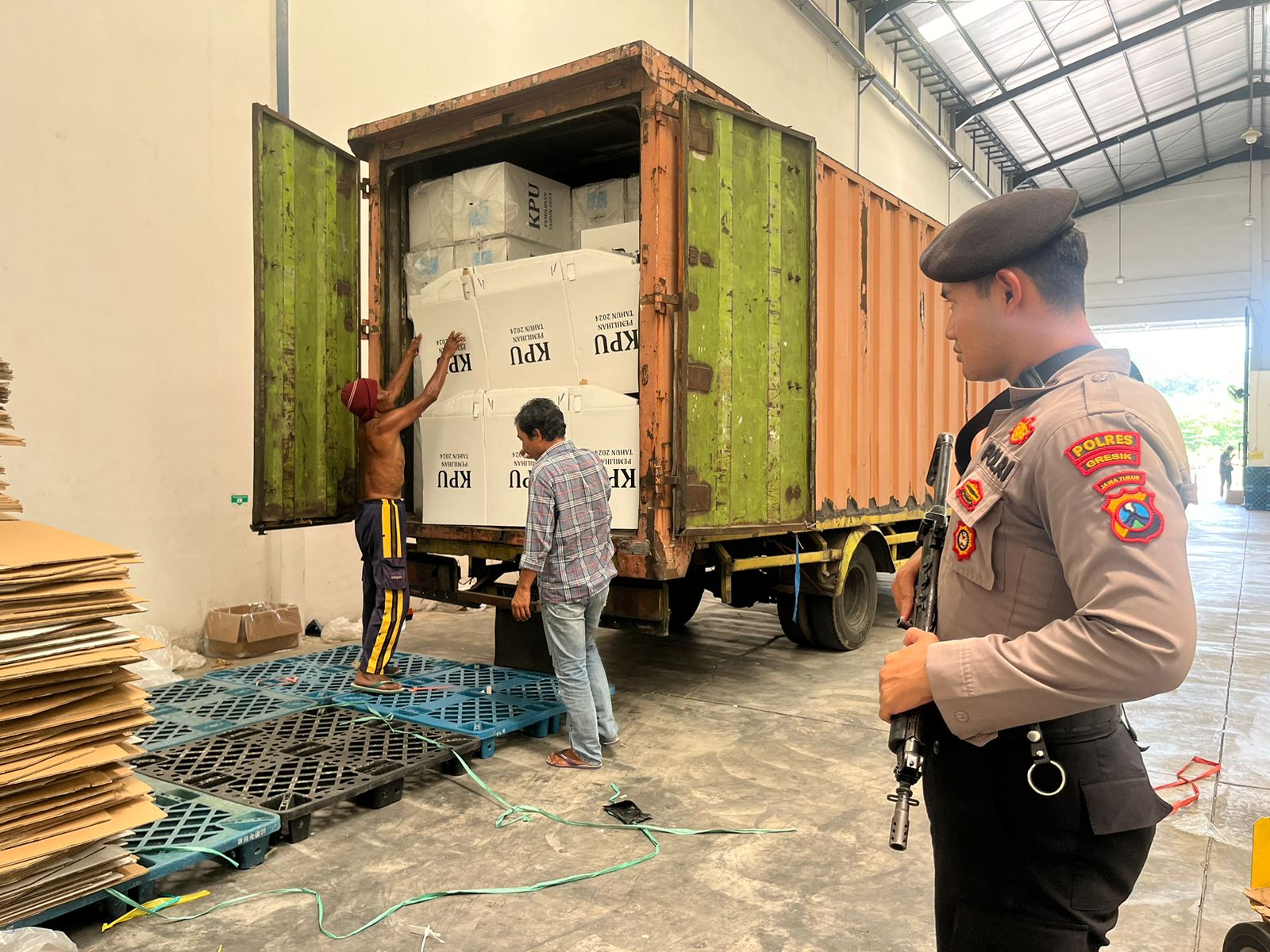 DIJAGA KETAT : Anggota Polres Gresik saat melakukan penjagaan pengamanan Gudang Logistik Pemilu 2024 di Desa Sekarkurung, Kecamatan Kebomas, Kabupaten Gresik.