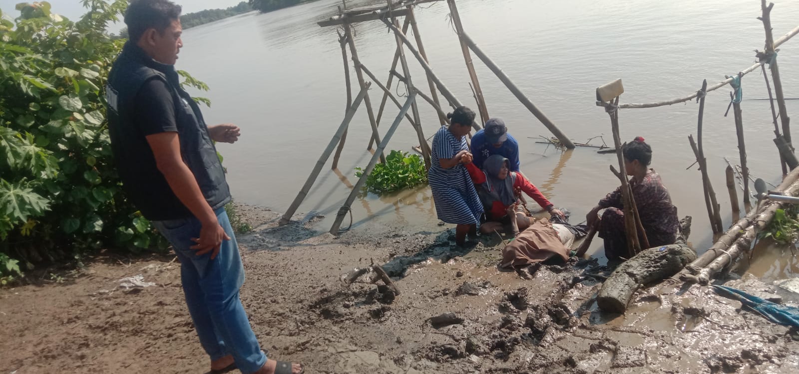 DIEVAKUASI : Anggota Polsek Bungah, warga dan petugas Puskesmas Bungah saat melakukan evakuasi korban ditepi Sungai Bengawan Solo masuk wilayah Desa Bedanten, Kecamatan Bungah, Kabupaten Gresik.