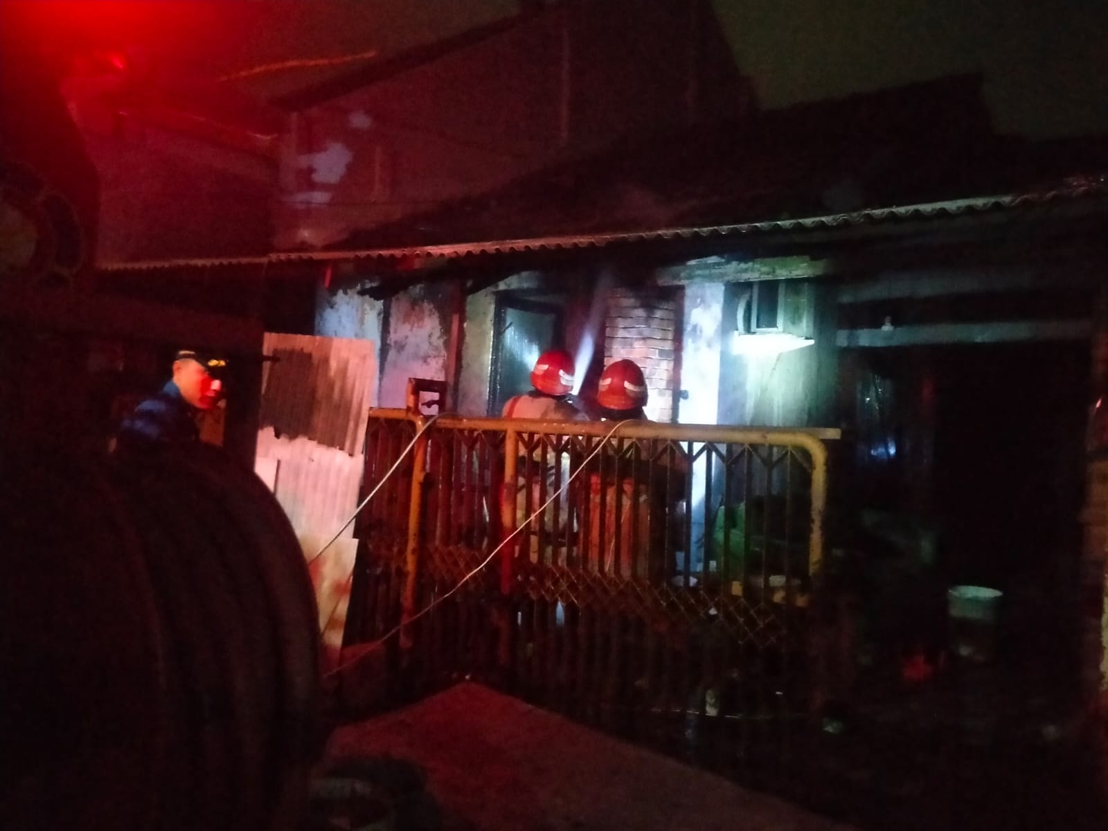 PEMBASAHAN: Petugas Damkarla Kabupaten Gresik saat melakukan pemadaman dan pembasahan kebaran di sebuah rumah Desa Gadung, Kecamatan Driyorejo,Gresik .