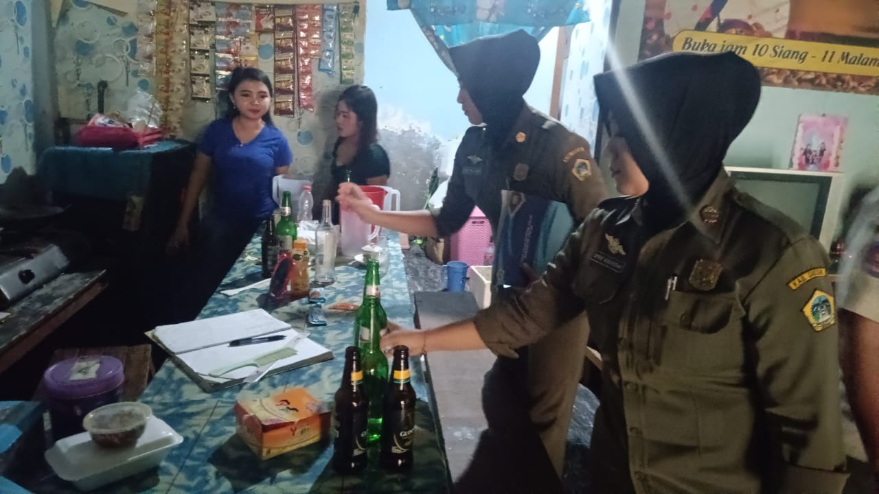 DIAMANKAN : Petugas gabungan saat mengamankan puluhan botol miras saat razia di warung kopi dan Cafe di Jalur Pantura, Gresik.
