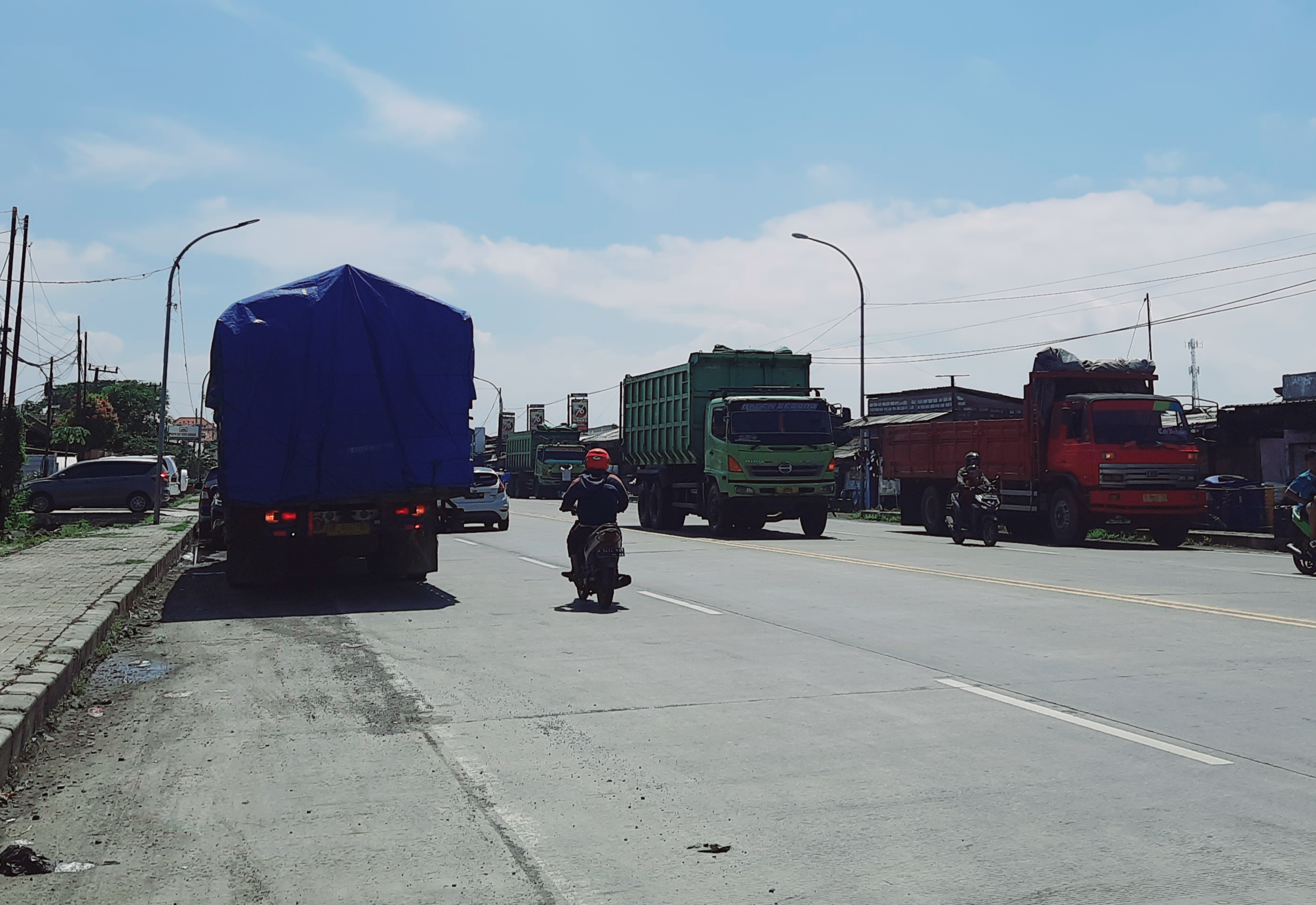PARKIR LIAR: Banyaknya truk parkir di tepi Jalan Duduksampeyan menjadi salah satu penyebab kecelakaan.