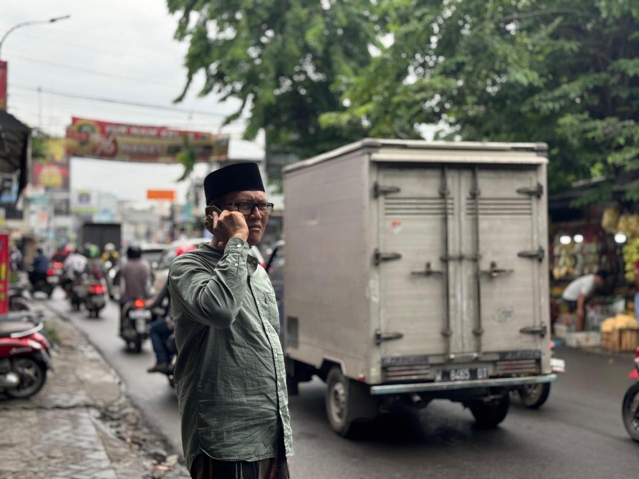 MEMANTAU: Wakil Ketua Komisi III DPRD Gresik Abdullah Hamdi saat melihat kondisi Jalan Menganti.