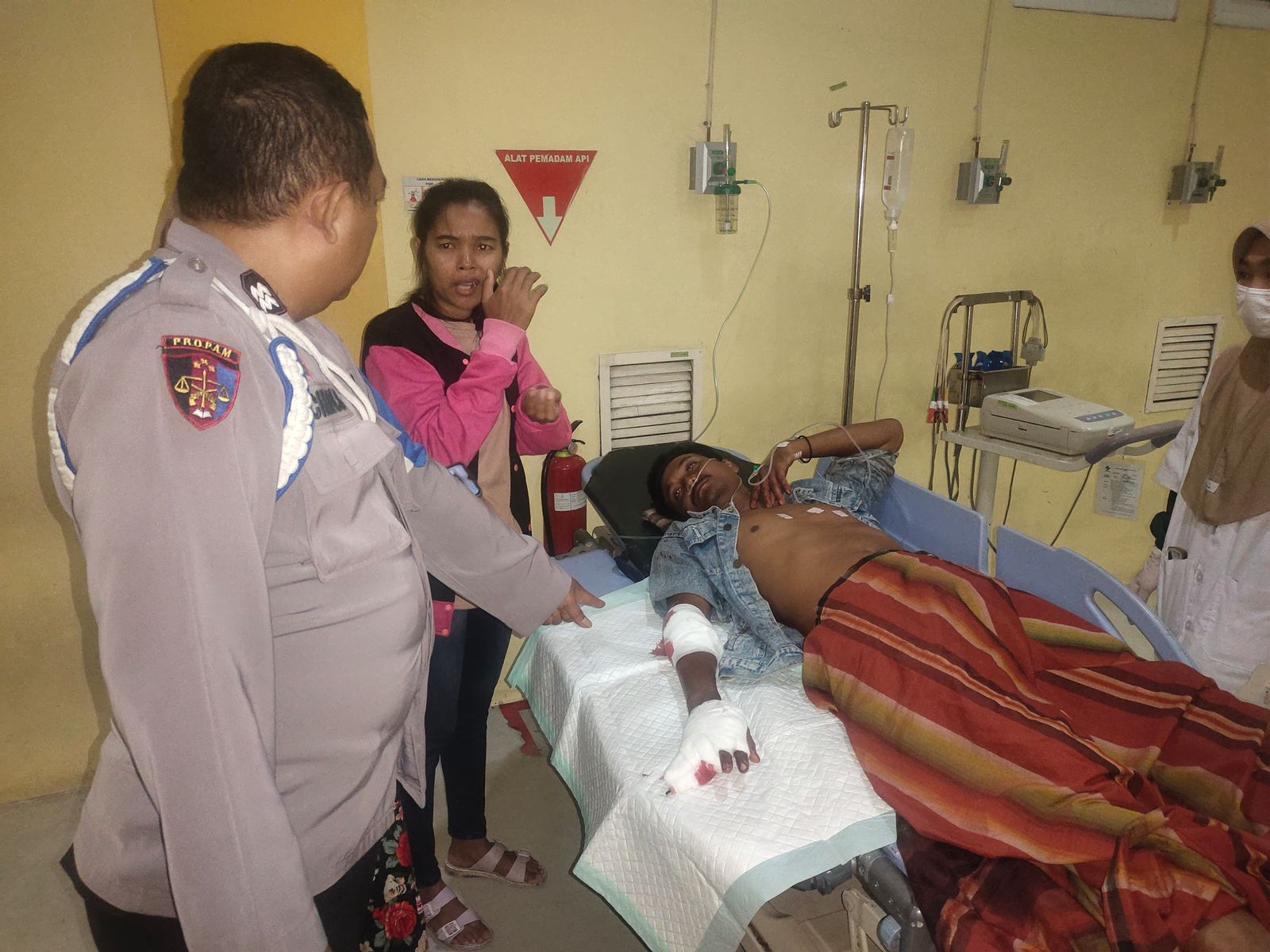 DIRAWAT: Korban pembacokan Asnan saat dirawat dan dimintai keterangan oleh anggota Polsek Balongpanggang, Gresik.