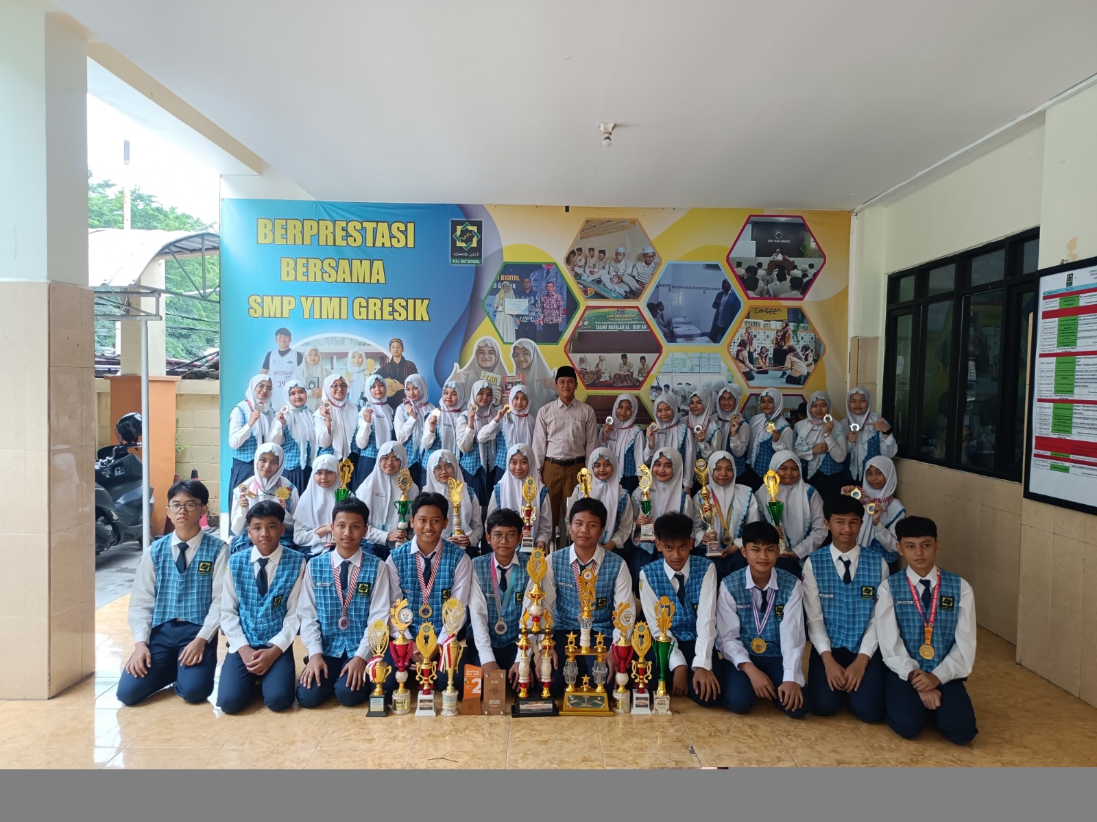 BANGGA: Kepala SMP YIMI Ainun Naim bersama siswa-siswi peraih berbagai prestasi.
