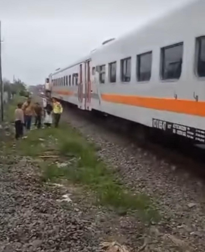 DISELAMATKAN: Petugas keamanan dan pegawai stasiun bersama warga saat mengamankan korban percobaan bunuh diri di dekat rel perlintasan di Duduksampeyan Gresik.