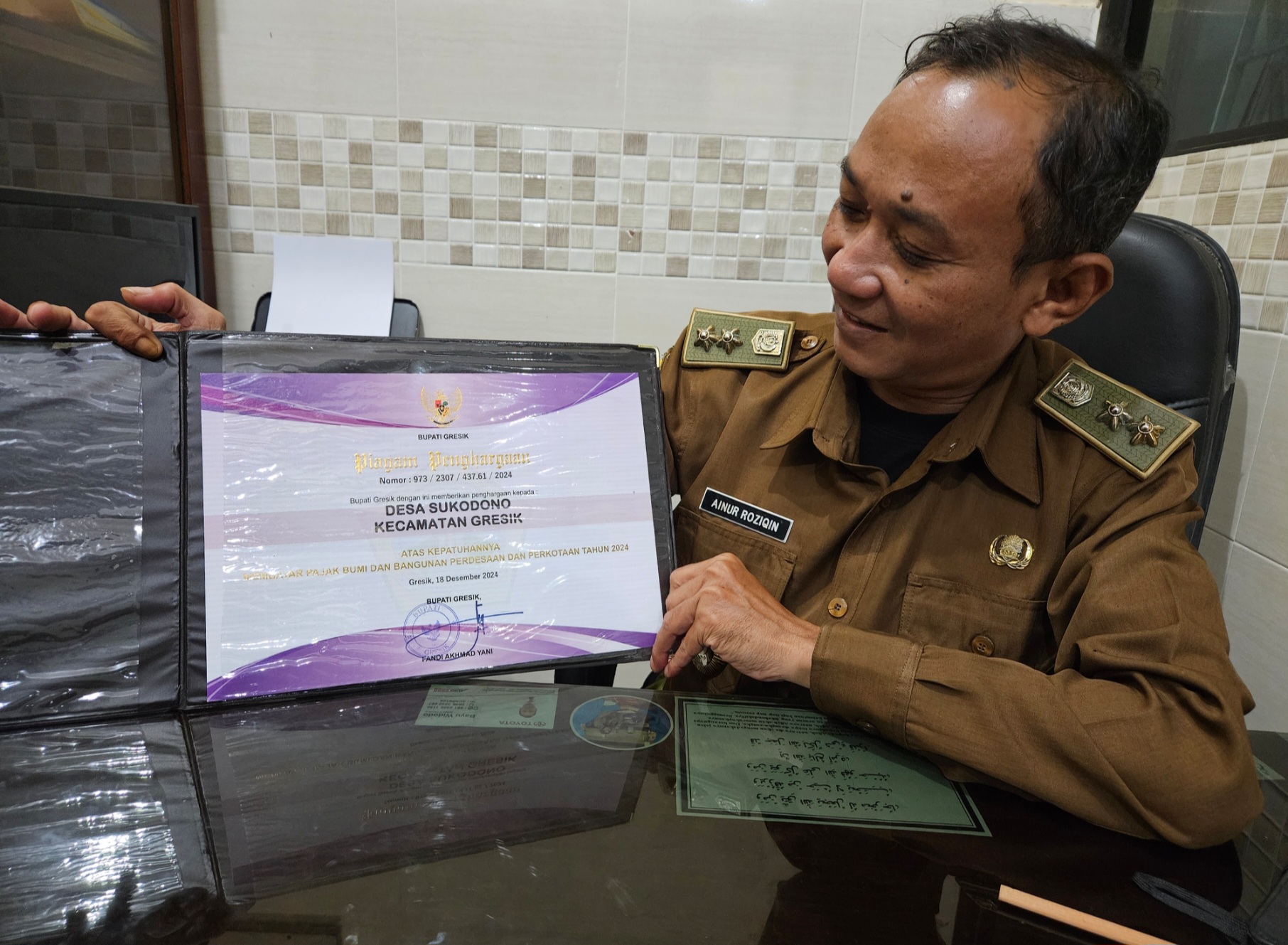 Bangga : Lurah Sukodono, Ahmad Roziqin menunjukkan piagam penghargaan yang dia terima.