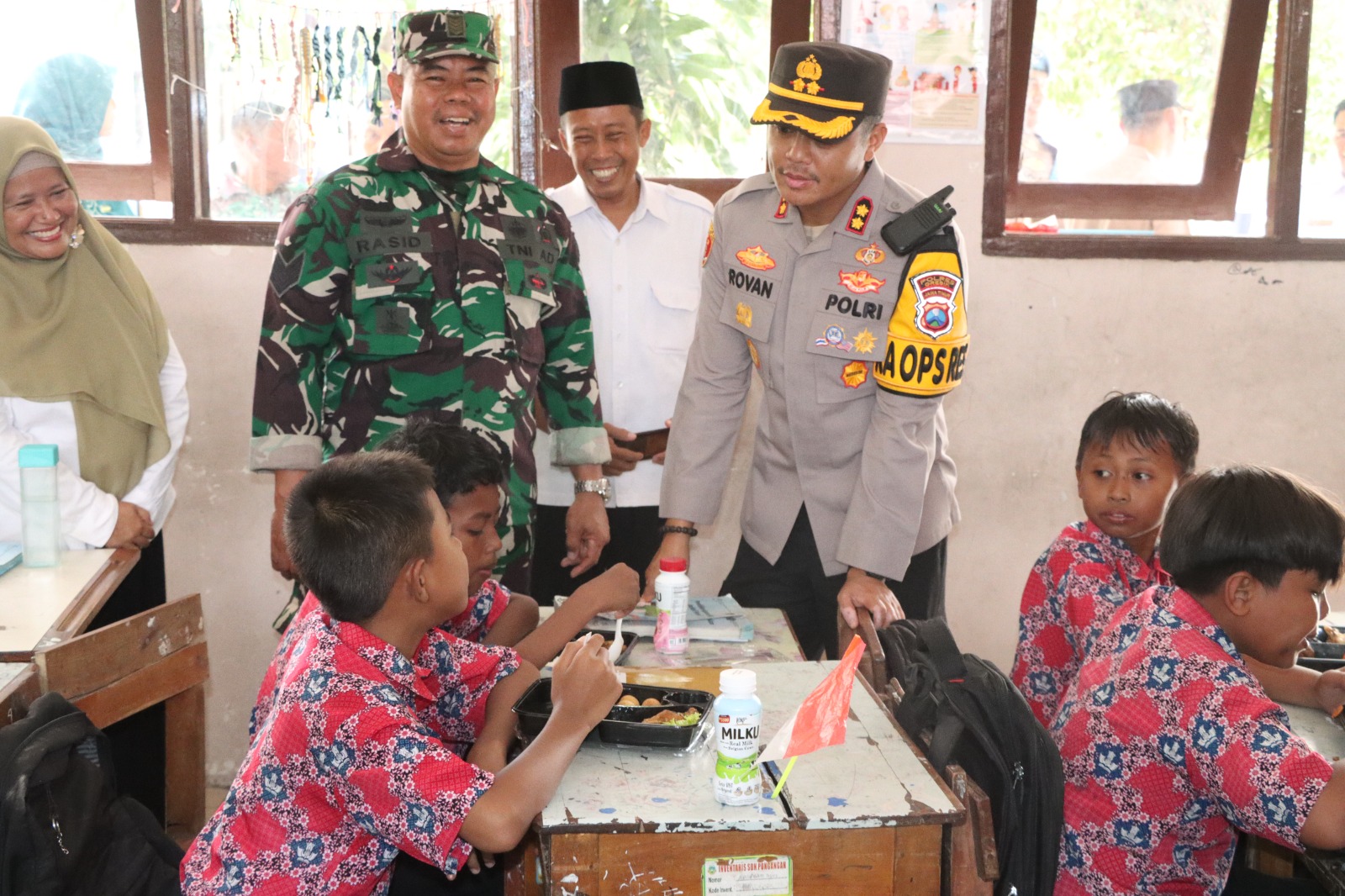 MAKAN GRATIS: Kapolres Gresik AKBP Rovan Richard Mahenu saat memantau langsung program makan bergizi gratis di UPT SD Negeri 51 Yosowilangun, Kecamatan Manyar, Gresik.