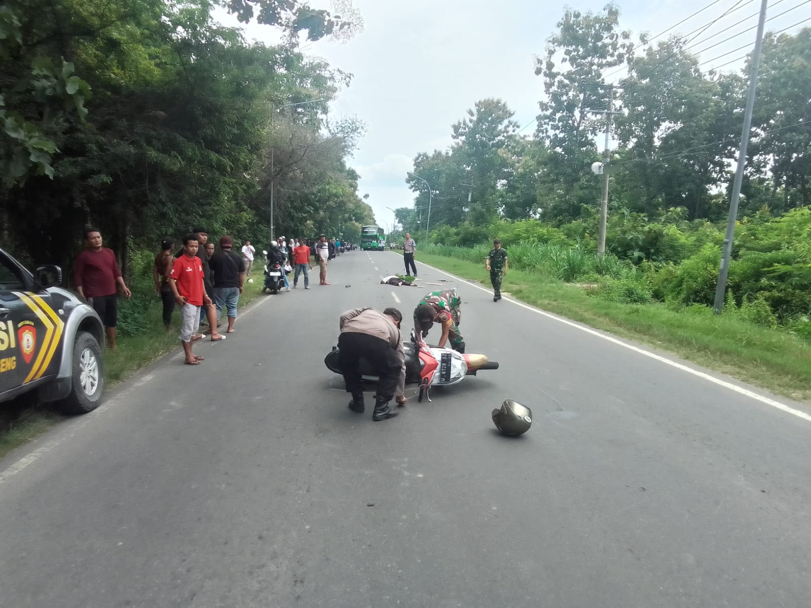 EVAKUASI: Anggota Polsek Panceng dibantu anggota Koramil Panceng saat melakukan evakuasi korban dan kendaraan milik korban di lokasi kejadian kecelakaan di Jalan Raya Desa Surowiti, Kecamatan Panceng,