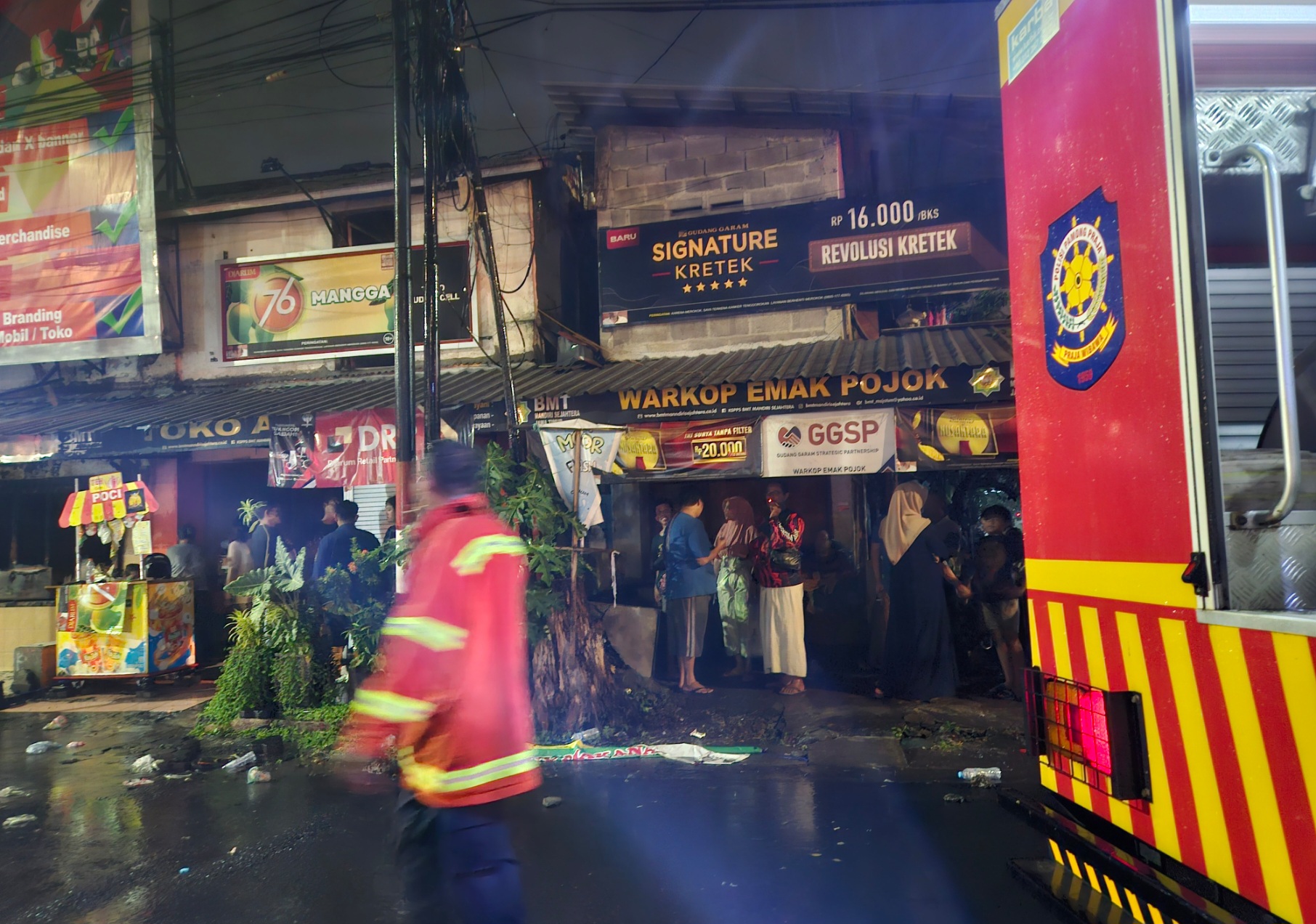 Kelam : Petugas Pemadam Kebakaran Pemkab Gresik berjibaku memadamkan api yang melahap warung nasi Jalan Basuki Rahmat.