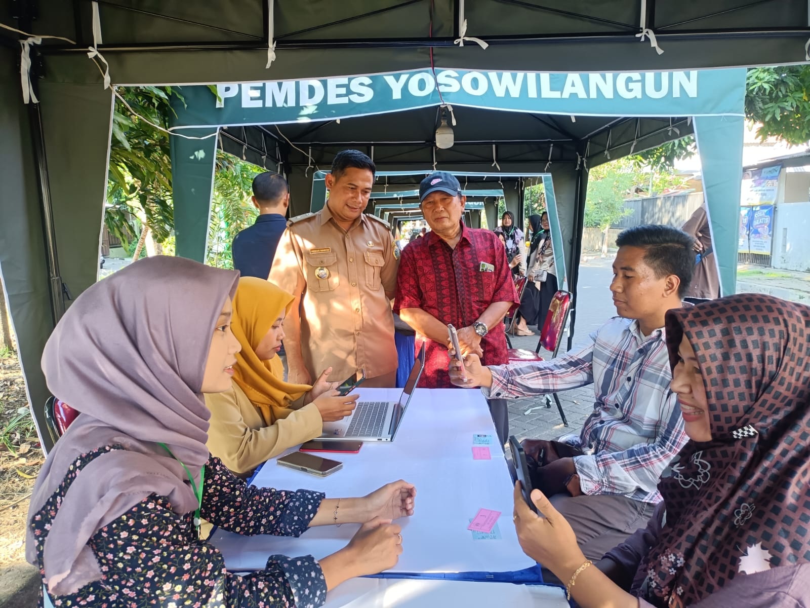 Antusiasme : Kepala Desa Yosowilangun H. Abdur Rosyid didampingi ketua RT 02 RW 09 Suroso memantau proses pendaftaran IKD di salah satu stand.