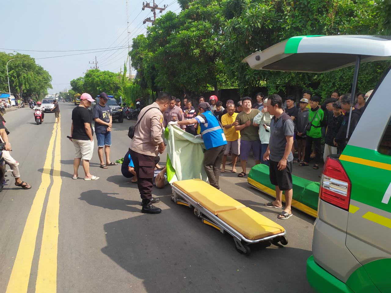 DIEVAKUASI: Anggota Polsek Manyar melakukan evakuasi korban kecelakaan di Jalan Raya Sukomulyo, Kecamatan Manyar, Gresik.