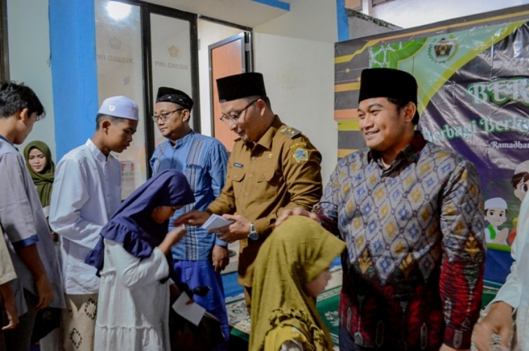 Wakil Bupati Gresik, dr. Asluchul Alif bersama Ketua DPRD Gresik, Muhammad Syahrul Munir memberikan santunan kepada anak yatim yang digelar PWI Gresik.