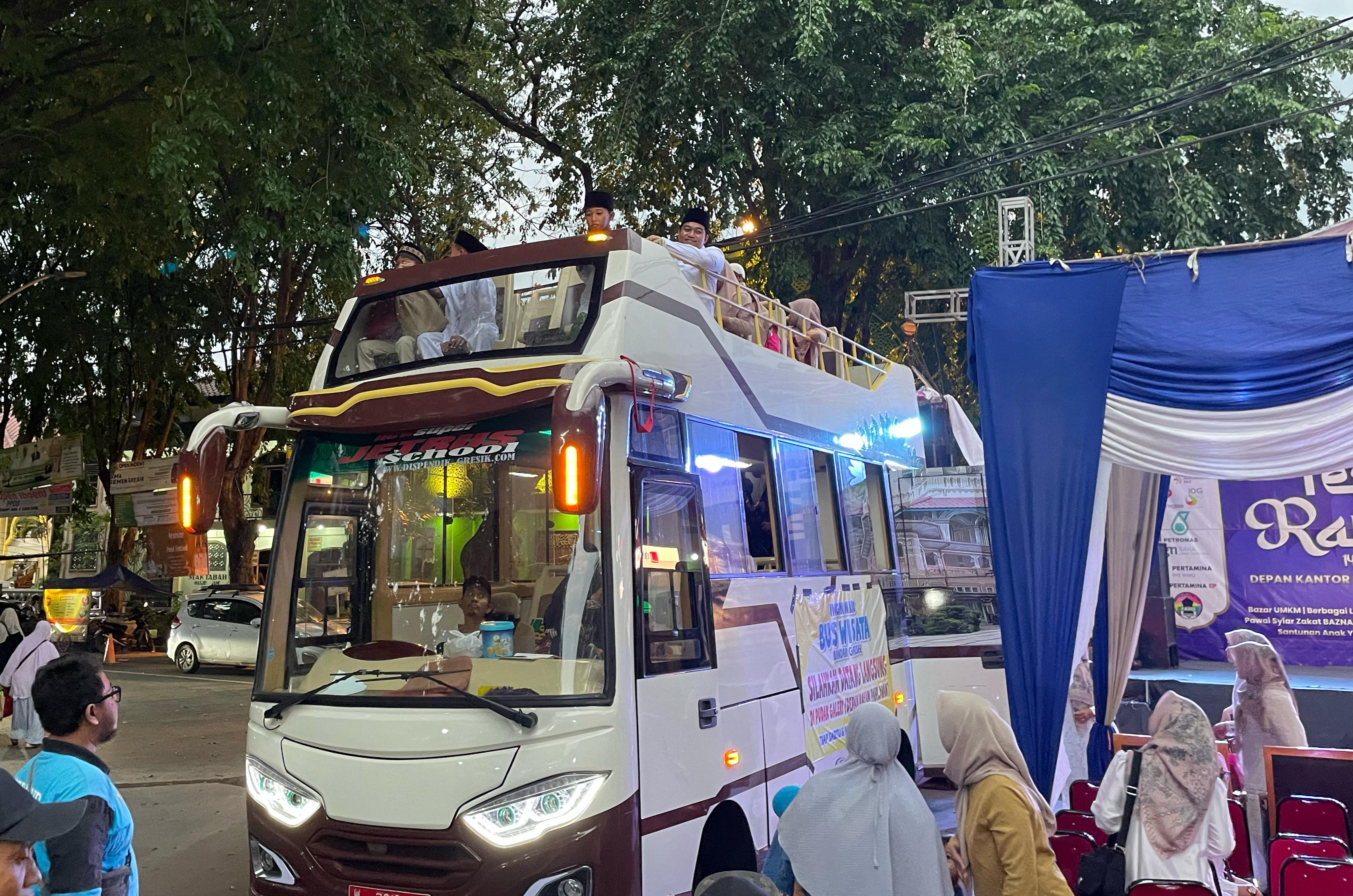 PENUH KEJUTAN: Usai mendapatkan santunan, Ketua DPRD Gresik M Syahrul Munir mengajak anak-anak naik bus wisata Bandar Grissee.