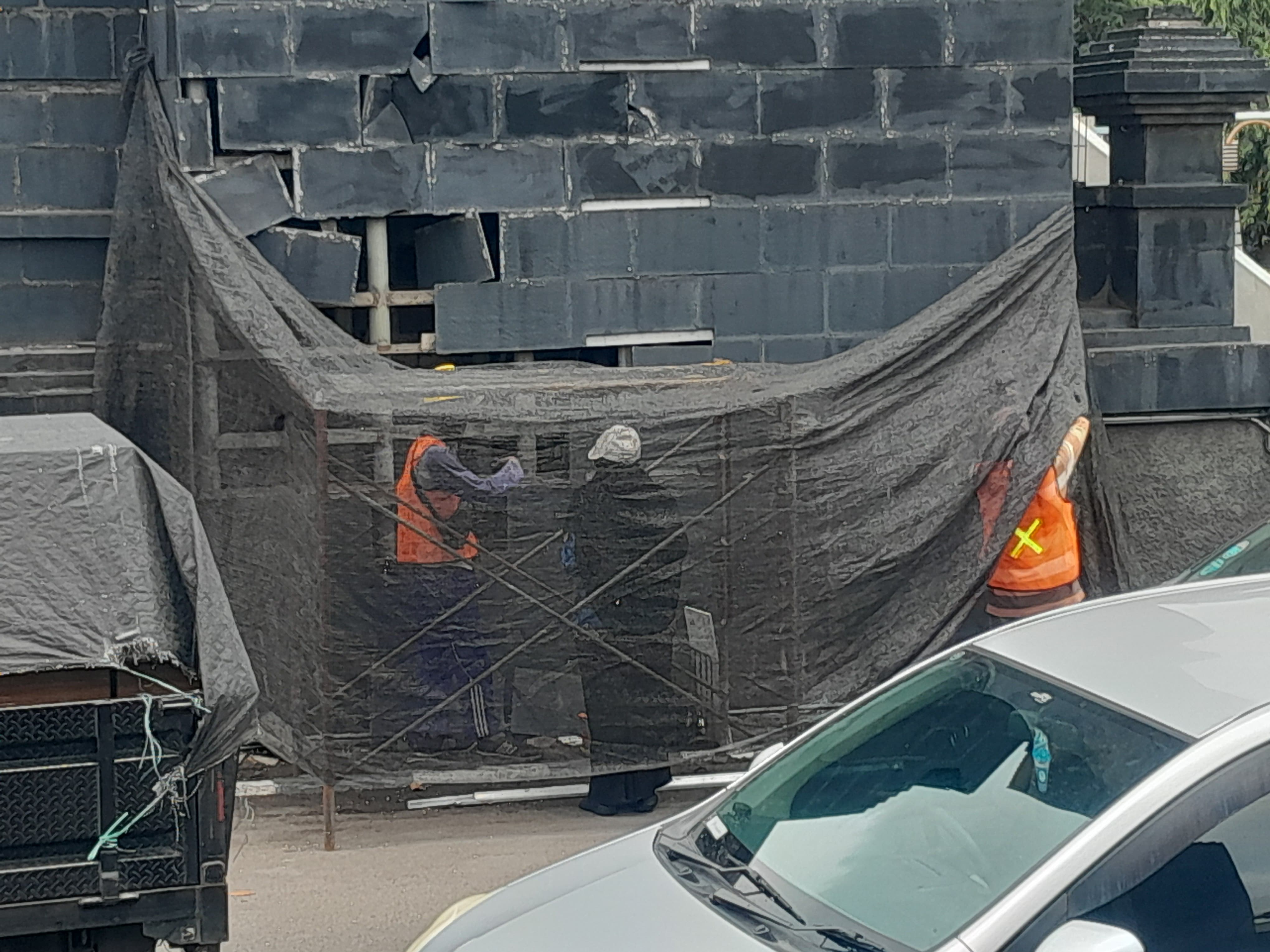 DIPERBAIKI : Kepala Dinas DLH Kabupaten Gresik Sri Subaidah turun langsung untuk mengecek dinding tugu selamat datang perbatasan Gresik-Surabaya rusak untuk di Perbaiki.