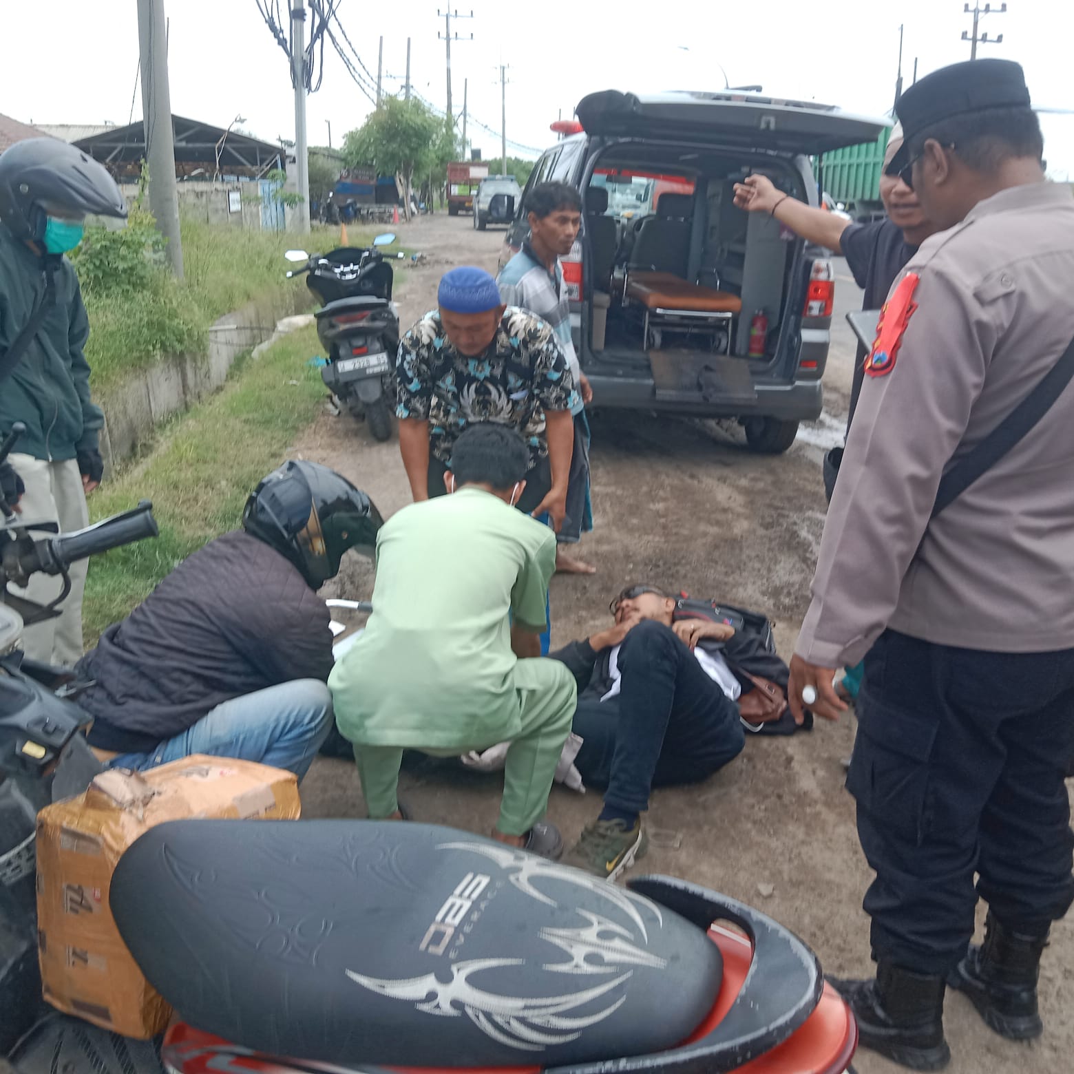 Dievakuasi: Anggota Polsek Manyar saat melakukan evakuasi korban kecelakaan di Kecamatan Manyar, Gresik.