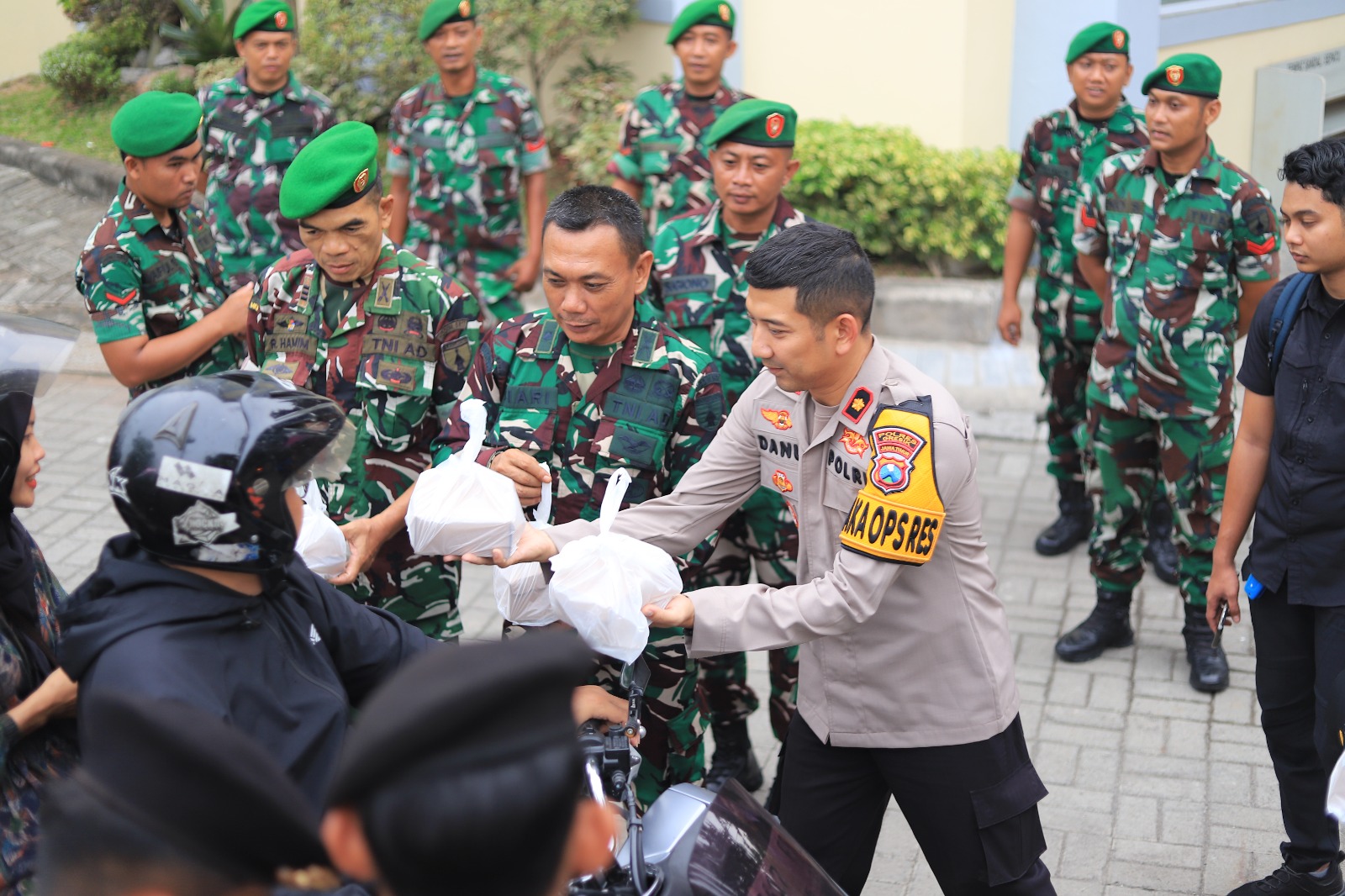 BERBAGI : Anggota Polres Gresik dan Kodim 0817 Gresik saat membagikan takjil untuk masyarakat yang melintas di Mapolres Gresik.