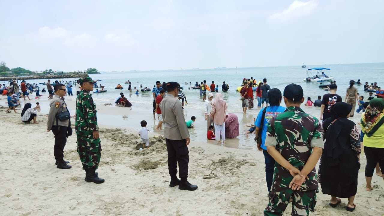 PENGAMANAN: Anggota TNI - Polri saat melakukan pengamanan wisatawan liburan Idul Fitri di Pantai Dalegan, Kecamatan Panceng, Gresik.