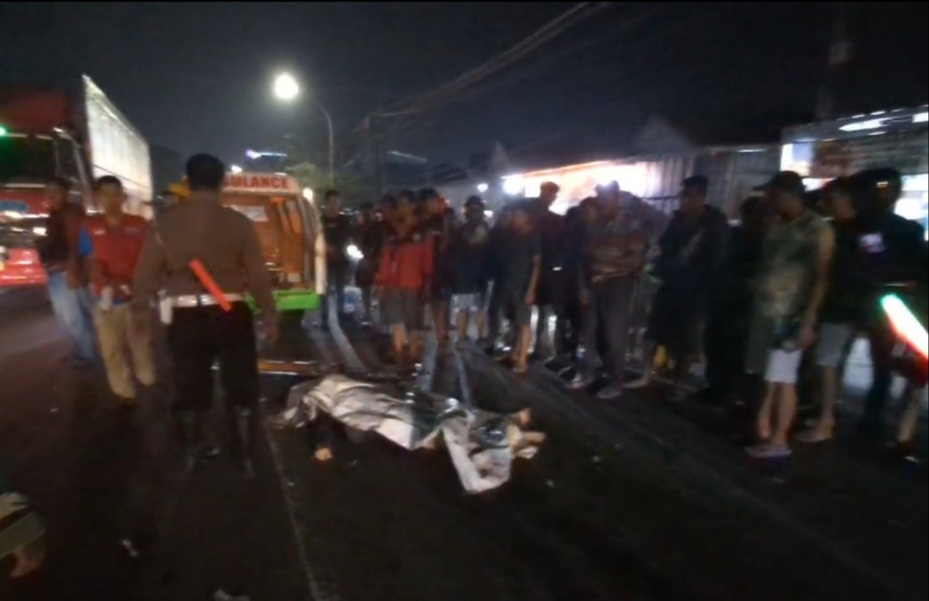 EVAKUASI : Anggota Polsek Driyorejo dibantu tim medis saat mengevakuasi korban Kecelakaan Jalan Raya Dusun Lopang, depan PT Diyasa, Kecamatan Driyorejo, Gresik.