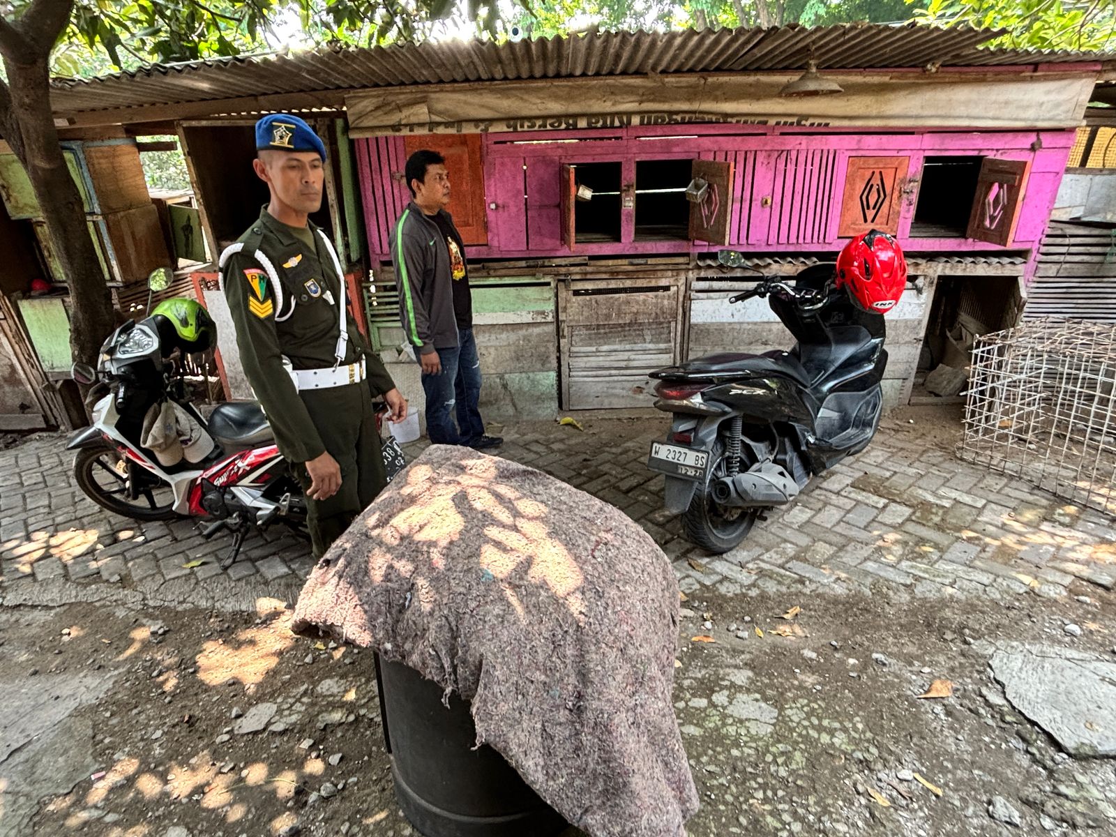 DIGREBEK: Anggota Polsek Kebomas dan personel VPM TNI saat menggrebek tempat diduga jadi lokasi perjudian sabung ayam di Jalan RA Kartini, Kelurahan Sidomoro, Kecamatan Kebomas, Gresik.