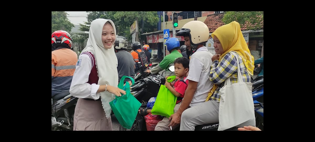 HARI BUMI : Para pelajar bagikan pupuk kompos dan tas ramah lingkungan kepada warga dan pengendara yang melintas di perempatan Sentolang, Kecamatan Kebomas, Gresik untuk peringati Hari Bumi.