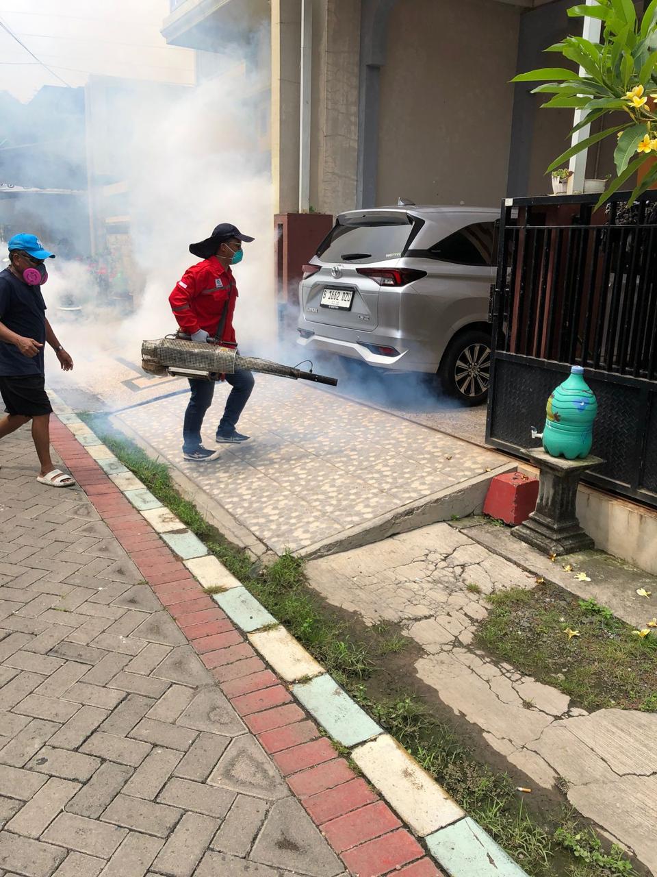 FOGGING: Petugas Dinkes Gresik melakukan fogging ke rumah warga.