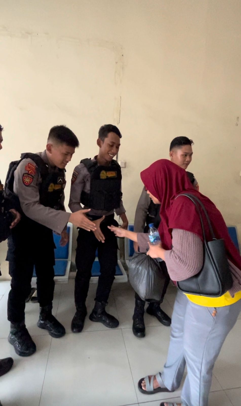 TANGGAP : Anggota Raimas Kalamunyeng Polres Gresik saat membantu Tia warga, Desa Lowayu, Kecamatan Dukun, Gresik yang diduga menjadi korban penipuan tenaga kerja dan terlantar di Terminal Bunder