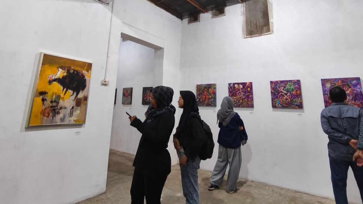 MELIHAT : Salah satu pengunjung melihat lukisan penuh makna