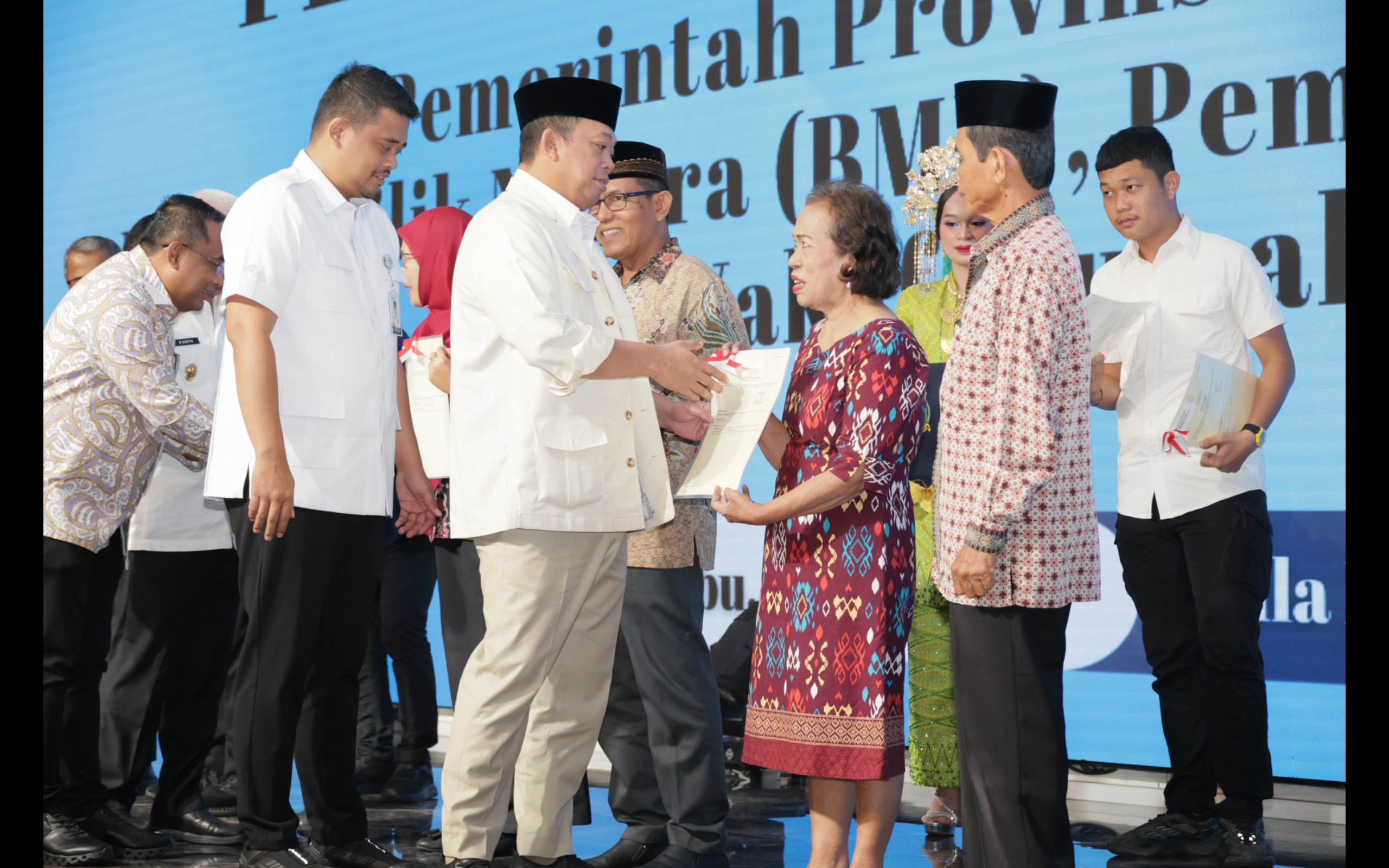 Menteri ATR/BPN Nusron Wahid didampingi Gubernur Sumut Bobby Nasution menyerahkan sertipikat kepada masyarakat.