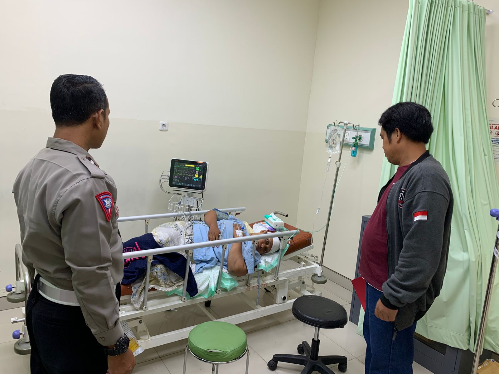 MARJUKI DIRAWAT: Korban pembacokan, Marjuki, mendapatkan perawatan medis di rumah sakit didampingi anggota Polsek Menganti, Gresik.