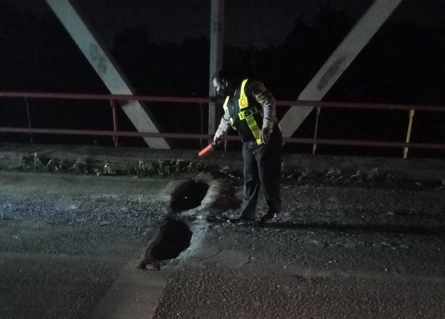 BERLUBANG: Anggota kepolisian saat mengecek jembatan Jrebeng penghubung Driyorejo-Krian yang berlubang.