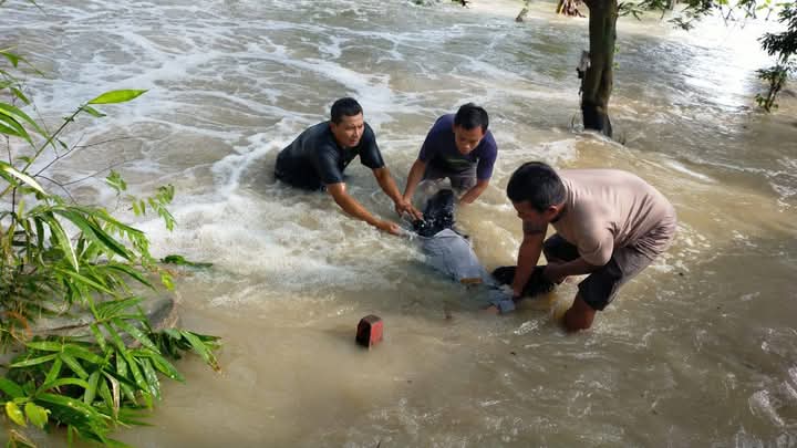 TERSERET BANJIR : Warga saat membantu Supriyadi petugas Dishub Gresik yang&nbsp; terseret arus Banjir luaoan Kali Lamong di Jalan Raya Ngablak, Desa Kedungrukem, Kecamatan Benjeng, Gresik.