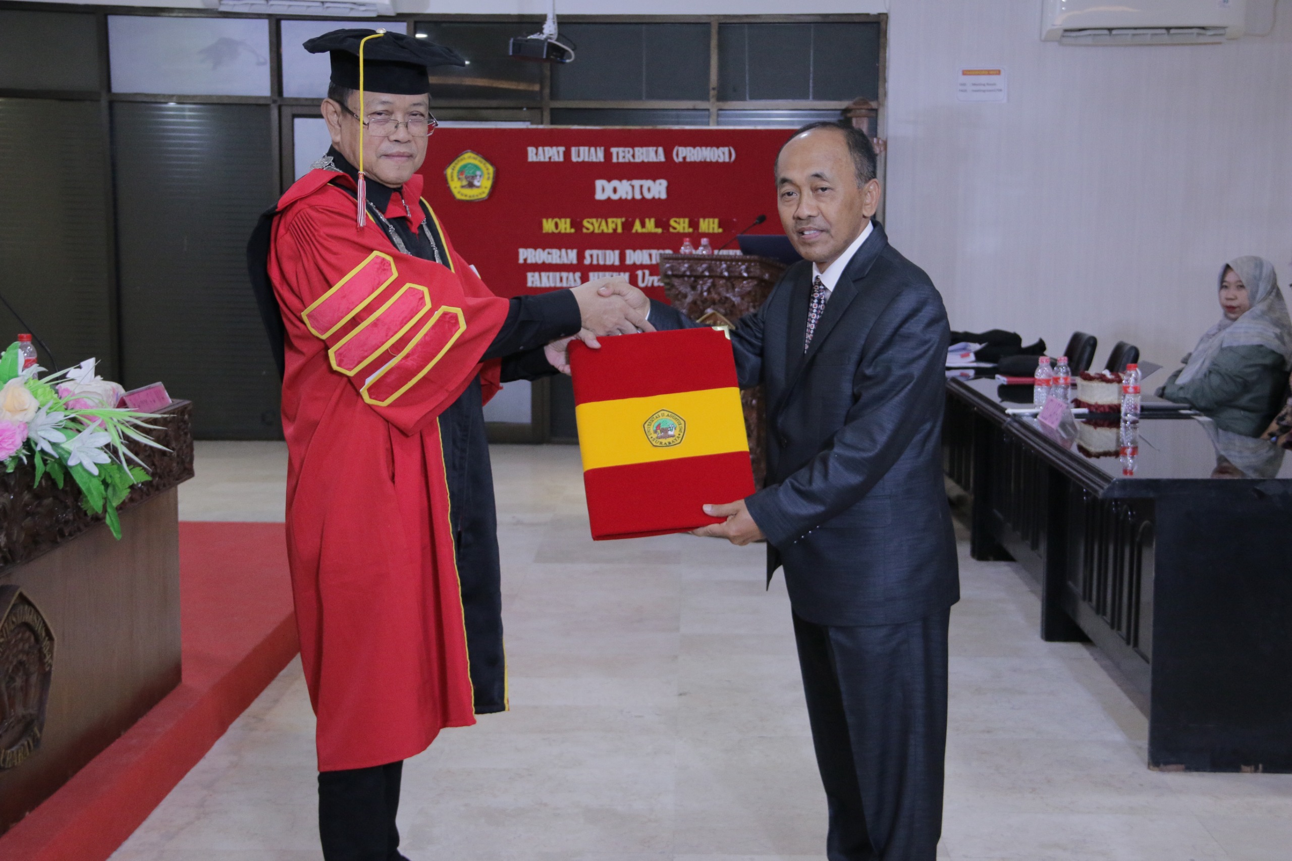 RESMI: Dekan FH Prof. Dr Slamet Suhartono, SH MH mengucapkan selamat  kepada M Syafi AM usai menjalani sidang terbuka doktor di Universitas 17 Agustus 1945.