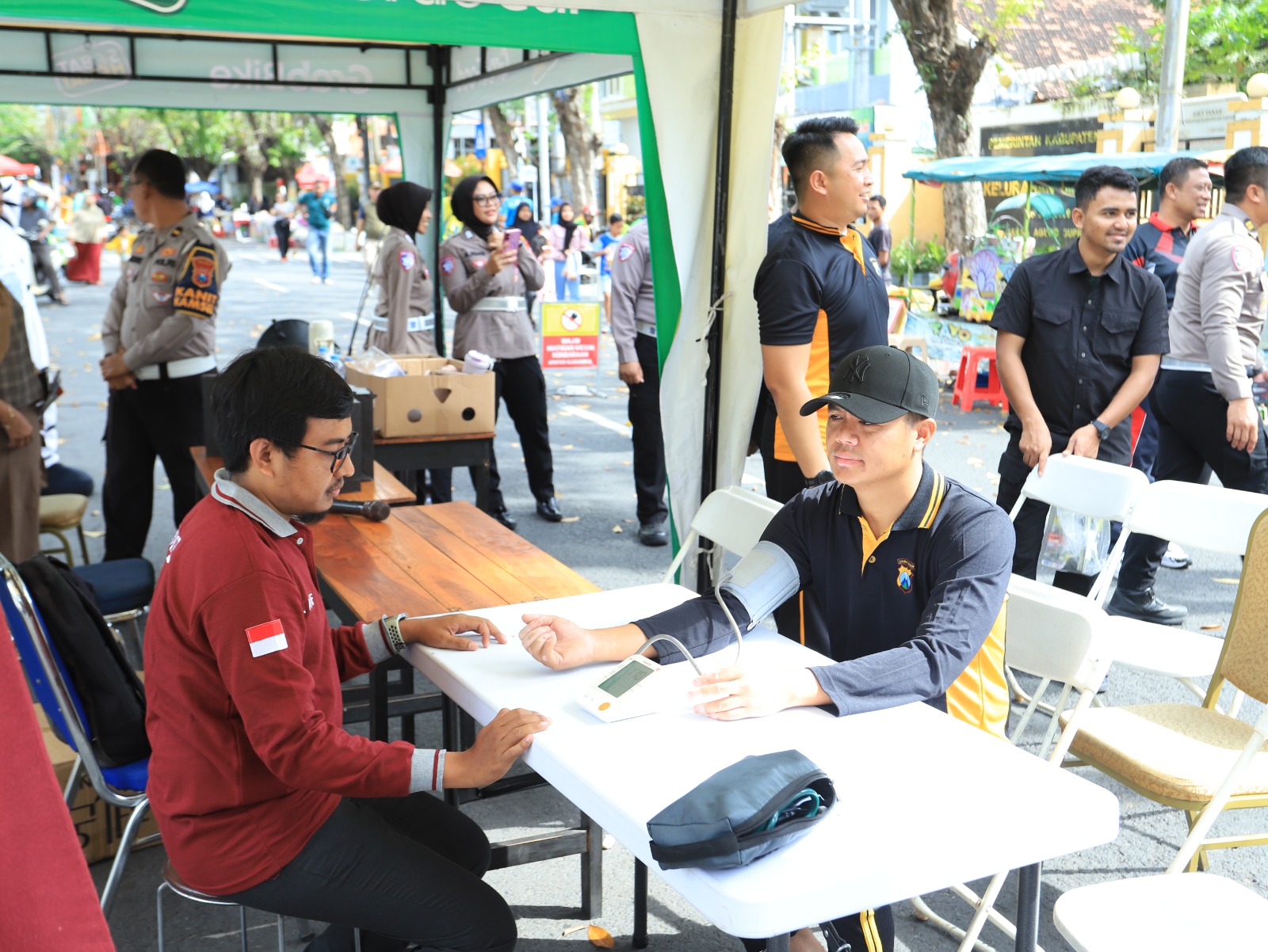 LAYANAN KESEHATAN: Kapolres Gresik AKBP Rovan Richard Mahenu saat memantau dan turut cek kesehatan di area CFD, Minggu (29/6/2025).