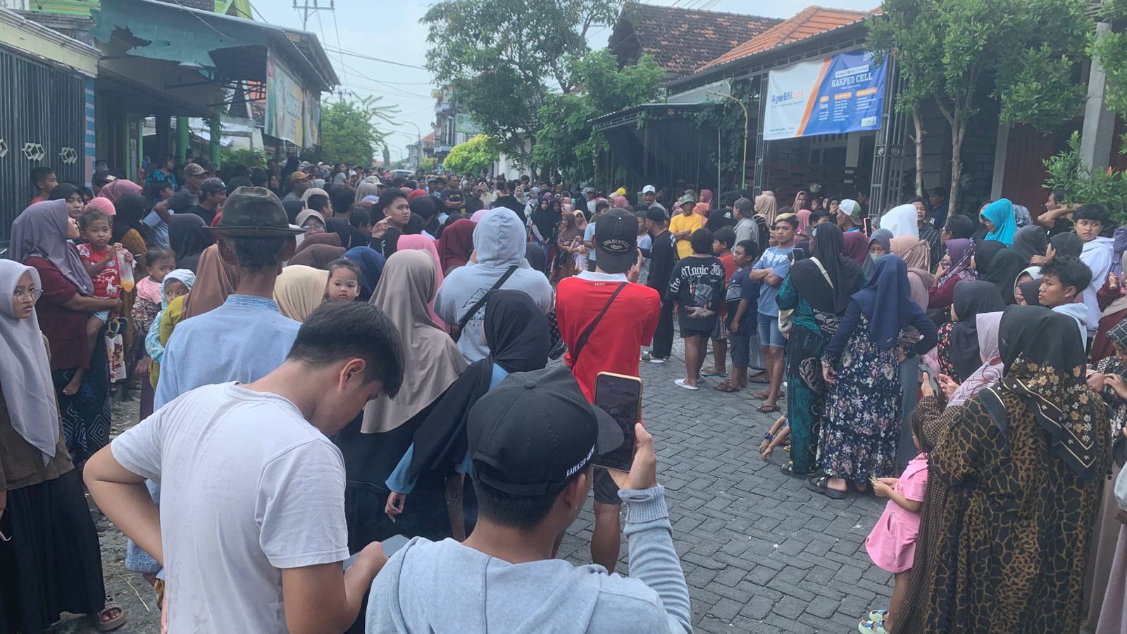 DITUNDA : Rekonstruksi ditunda warga Desa Imaan memadati jalan desa setempat sambil menunggu rekonstruksi pembunuhan yang dilakukan Ahmad Midhol.
