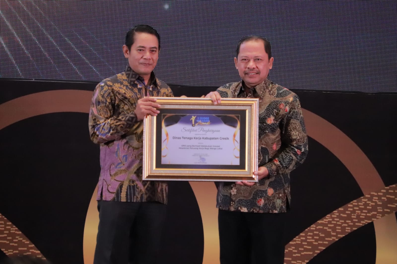 Direktur PT Radar Media Surabaya, Lilik Widyantoro menyerahkan penghargaan kepada Kepala Disnaker Gresik, Zainul Arifin, S.STP, M.M di Hotel Vasa Surabaya, Kamis (31/7/2025).