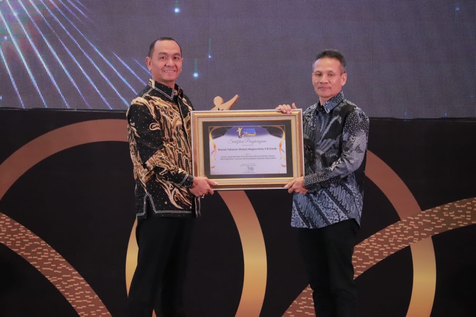 PENGHARGAAN: Yuliawan Dwi Nugroho, A.Md.IP., S.Sos., M.Si. Kepala Rumah Tahanan (Rutan) Negara Kelas IIB Gresik menerima penghargaan Radar Surabaya Award 2025 oleh Masrudi Nurwahid.
