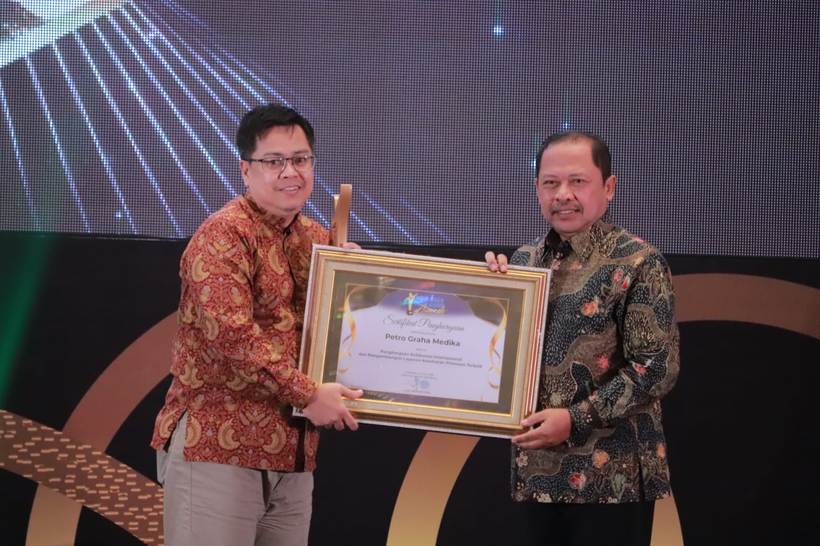 LAYANAN TERBAIK : Direktur Operasional PGM, dr. Ahdian Saptavani WF, M.KKK menerima penghasgaan secara langsung dari Direktur Utama PT Radar Media Surabaya, Lilik Widyantoro dalam acara RSA 2025.