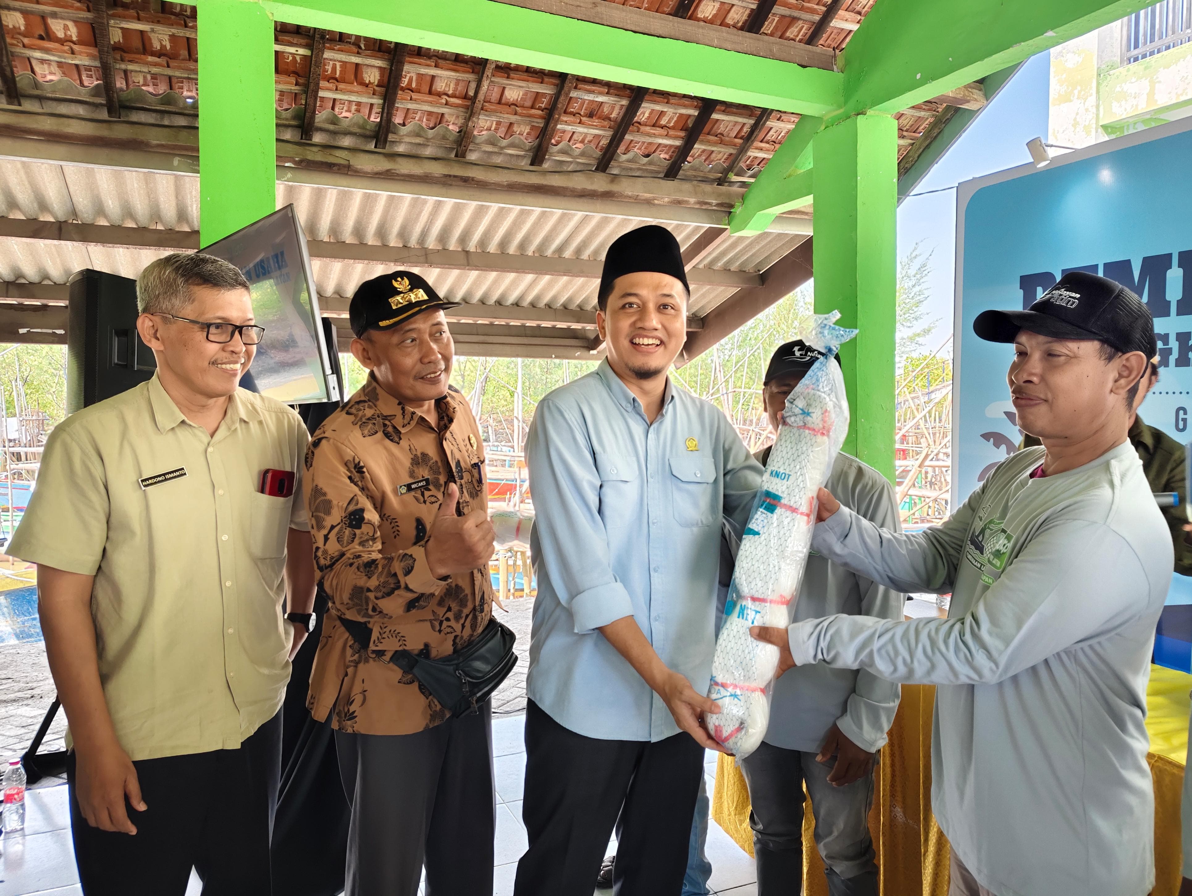 NELAYAN :&nbsp; Anggota Komisi II DPRD Gresik, Muhammad Kurdi saat memberikan alat tangkap ramah lingkungan ke nelayan