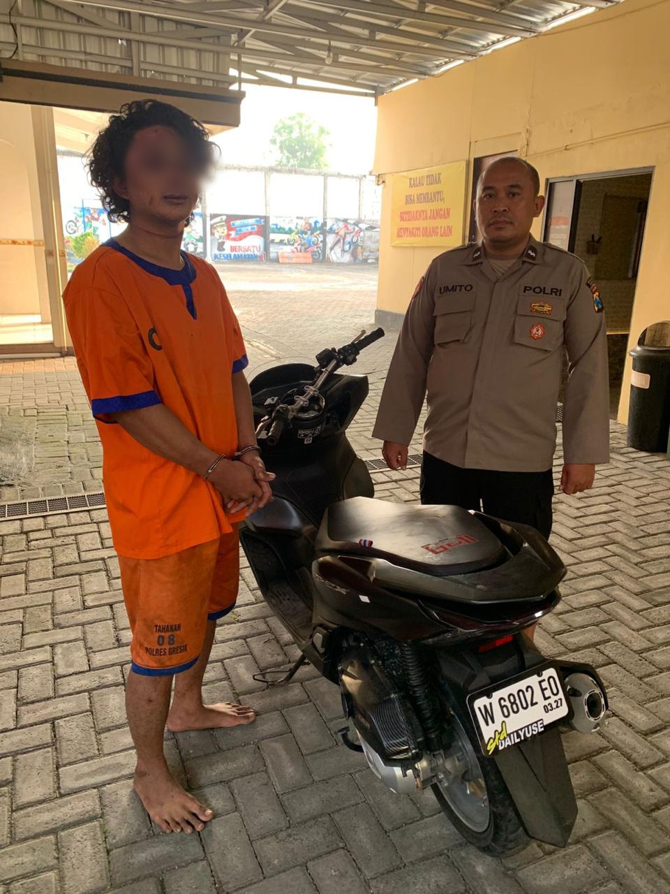 DIAMANKAN : Tersangka AIS saat diamankan beserta barang bukti motor curian di Mapolsek Menganti, Gresik.