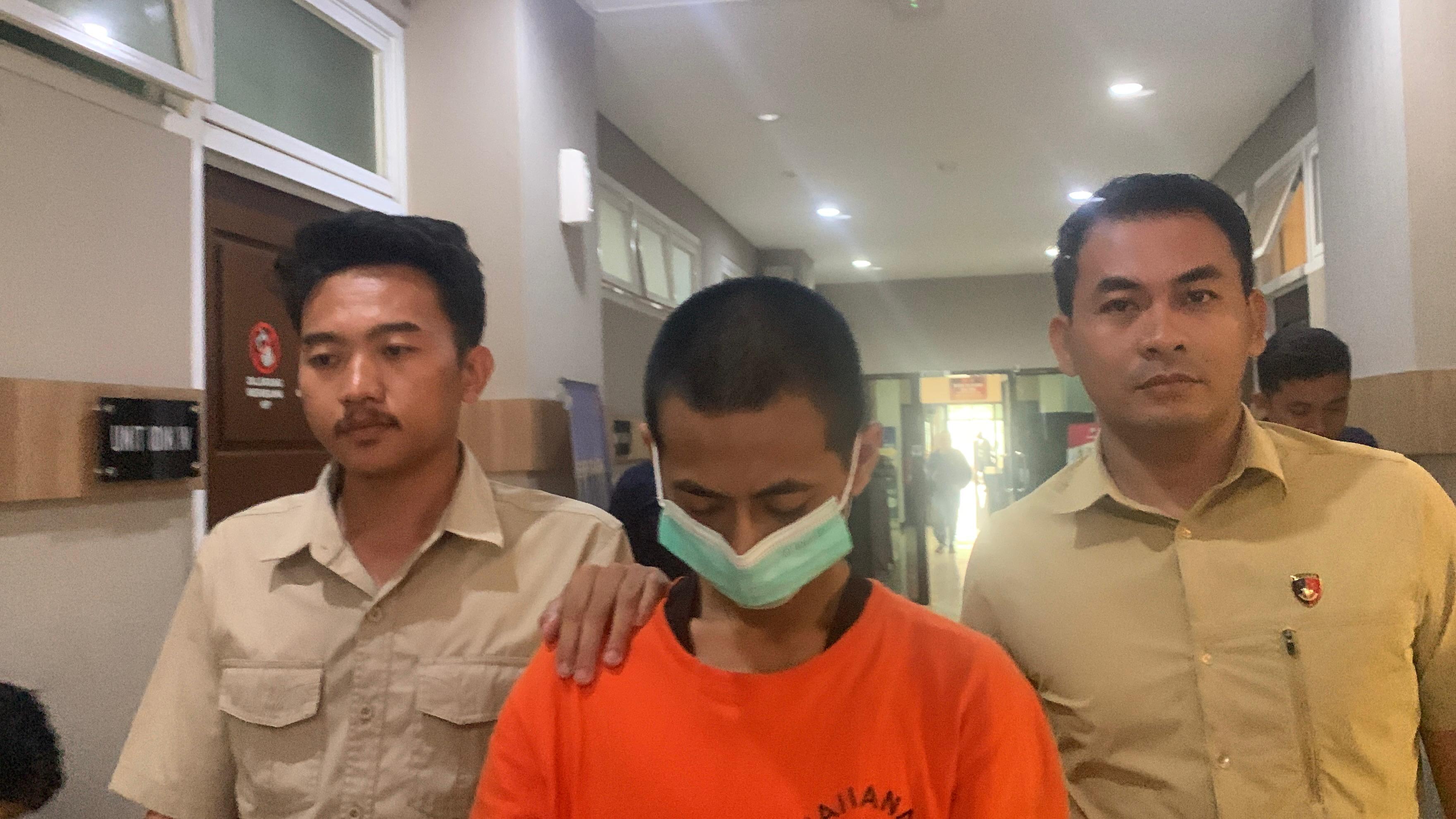 Keterangan Foto: Polisi mengamankan NT, tersangka kasus pencabulan anak di bawah umur, di Mapolres Gresik.