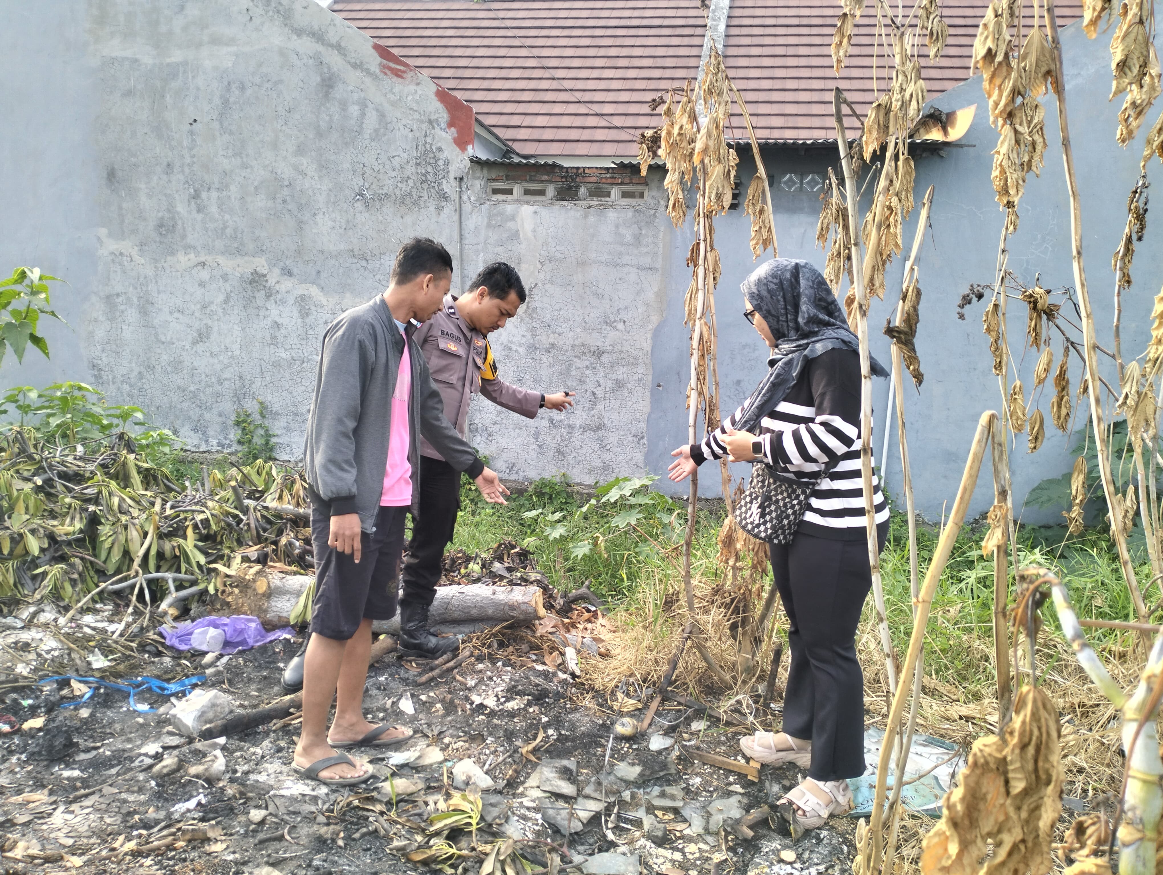 OLAH TKP : Anggota Polsek Manyar saat melakuaka olah TKP penemuan bayi yang dibuang dalam kantong plastik di Jalan Poros Tebalo Desa Tebalo, Kecamatan Manyar, Gresik tepatnya di dekat Perumahan.