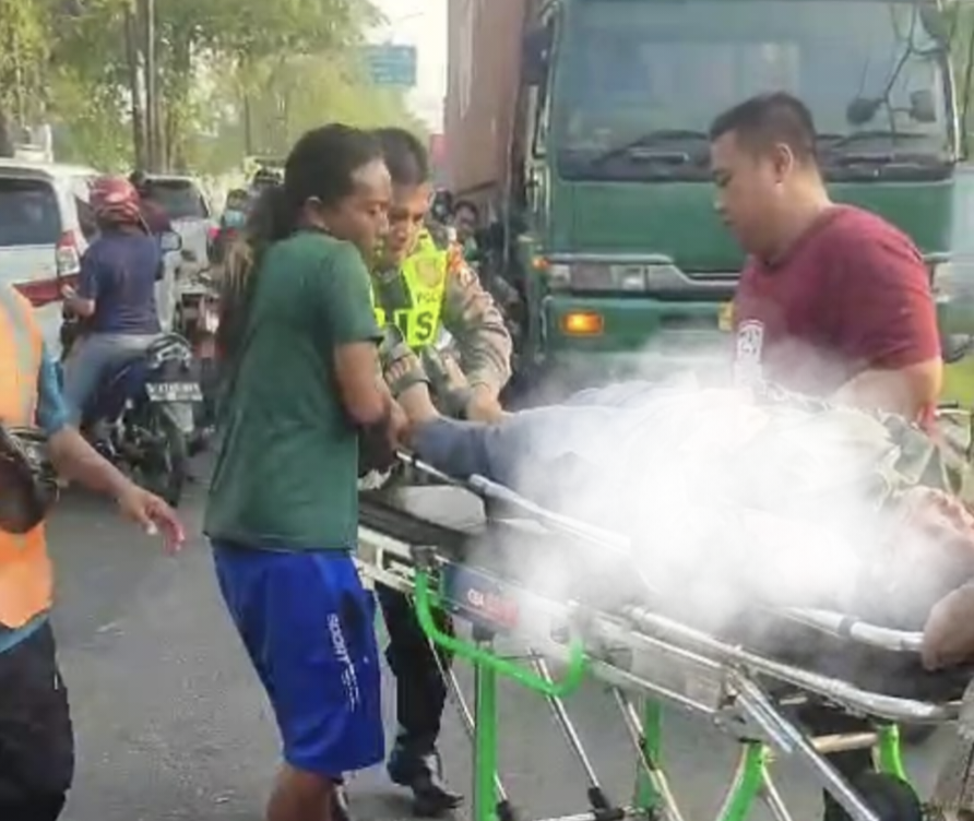 DIEVAKUASI : Petugas kepolisian saat melakukanevakuasi korban kecelakaan dibantu tim medis di Jalan Raya Tenaru, Desa Tenaru, Kecamatan Driyorejo, Kabupaten Gresik.