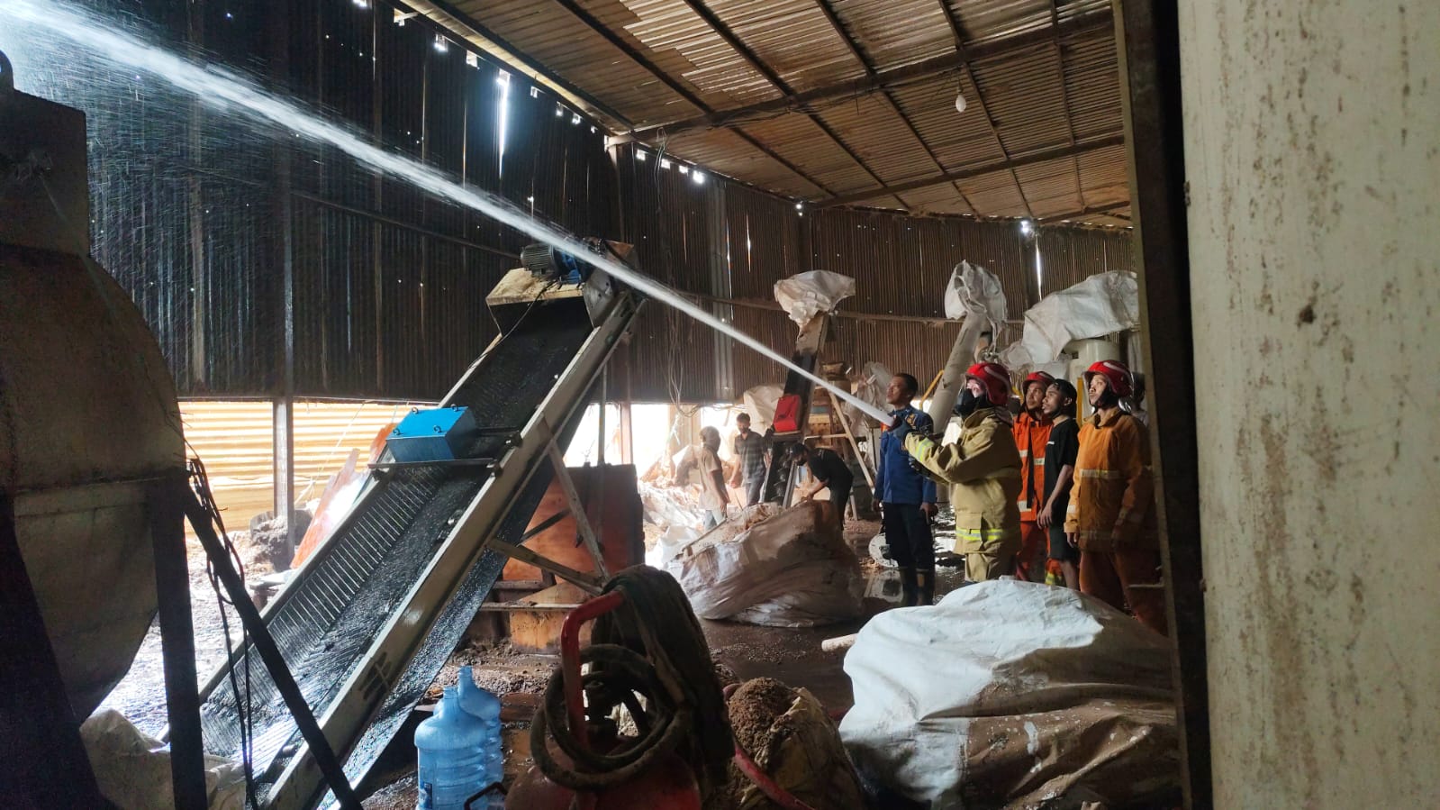 PENYEMPROTAN : Petugas Damkar Kabupaten Gresik saat melakukan penyemprotan kebakaran mesin produksi PT Sukses Pratama Lestari (SPL) Gresik di Jalan Raya Sembayat Km 12 nomor 8, Desa Banyutani, Manyar.